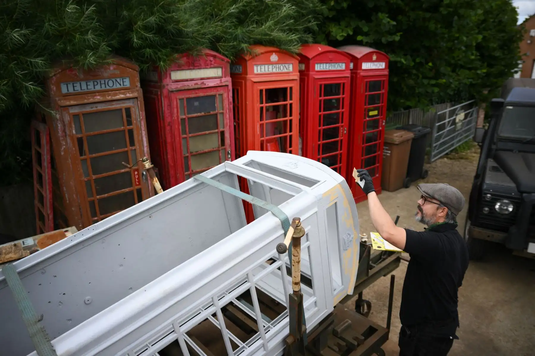 El propietario Carl Burge mira una cabina telefónica en su taller en "Remember When UK", una empresa especializada en restauración de recuerdos británicos en King
