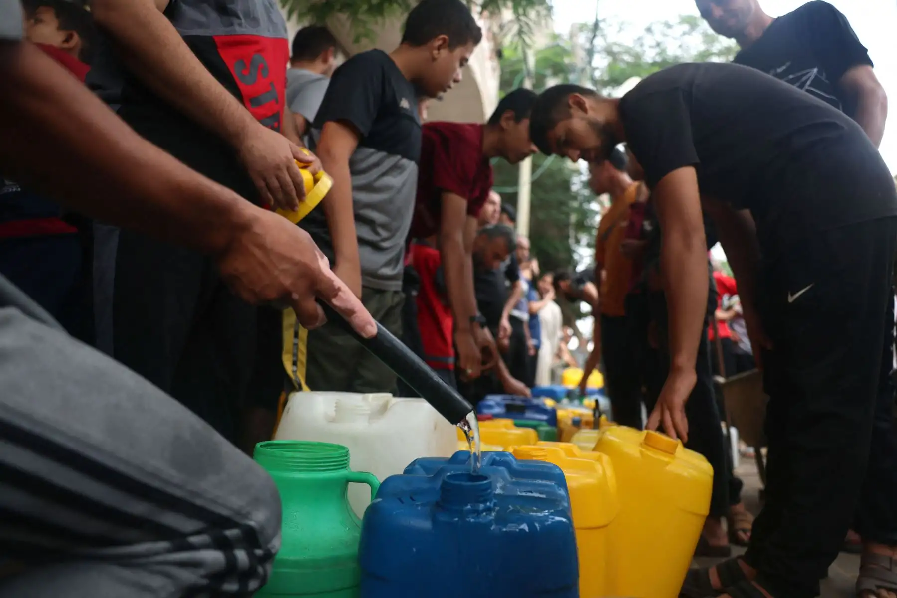 Los palestinos llenan bidones de plástico en un punto de llenado de agua portátil, en Rafah, en el sur de la Franja de Gaza, en medio de las batallas en curso entre Israel y el grupo palestino Hamás. Miles de civiles, tanto palestinos como israelíes. Foto: ANDINA/AFP