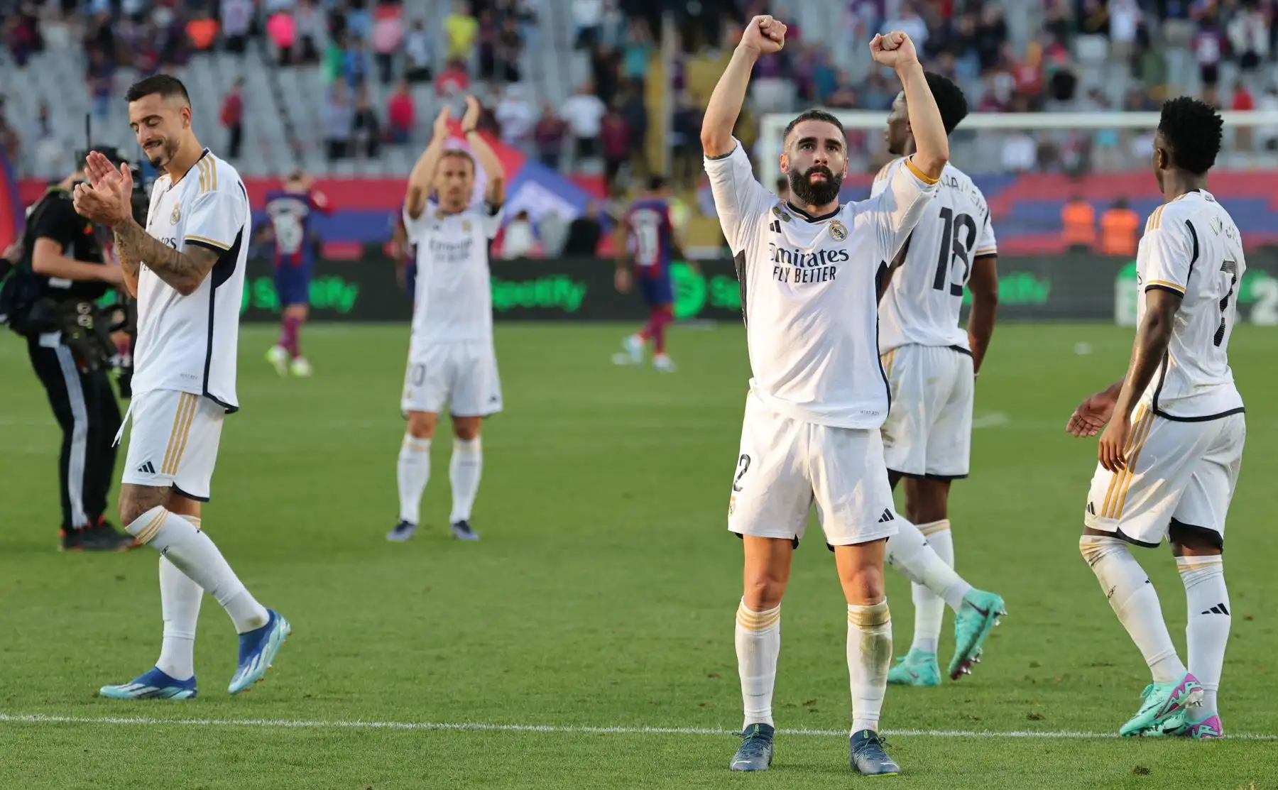 El delantero español del Real Madrid 14 Joselu , el defensor español del Real Madrid Dani Carvajal y sus compañeros celebran su victoria al final del partido de fútbol de la liga española entre el FC Barcelona y el Real Madrid CF en el Estadi Olimpic Lluis Companys en Barcelona. Foto: ANDINA/ AFP