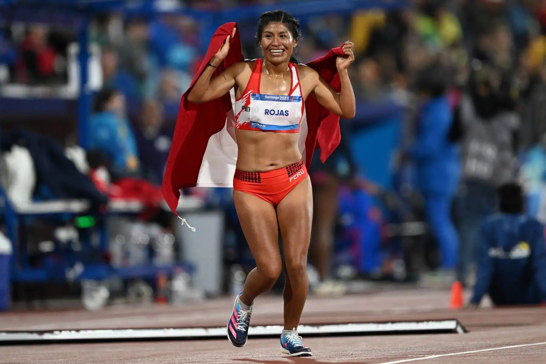 La peruana Luz Mery Rojas Llanco celebra tras ganar la final femenina de 10.000 m de los Juegos Panamericanos Santiago 2023 en el Estadio Nacional de Santiago. Foto: ANDINA/ AFP