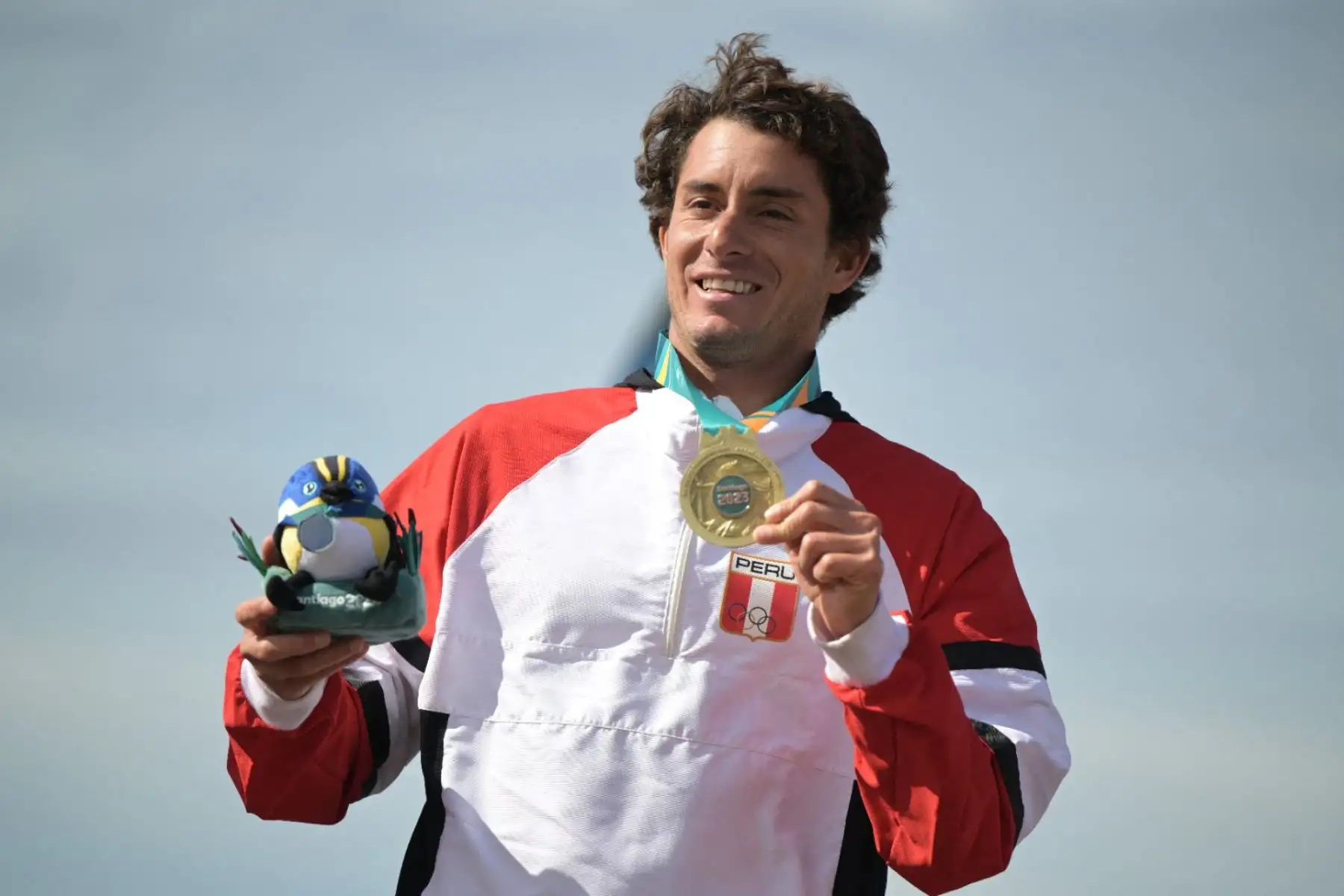 El peruano Lucca Mesinas posa en el podio con su medalla de oro tras la final masculina de surf shortboard de los Juegos Panamericanos Santiago 2023 en la playa Punta de Lobos de Pichilemu, Chile. Foto: AFP