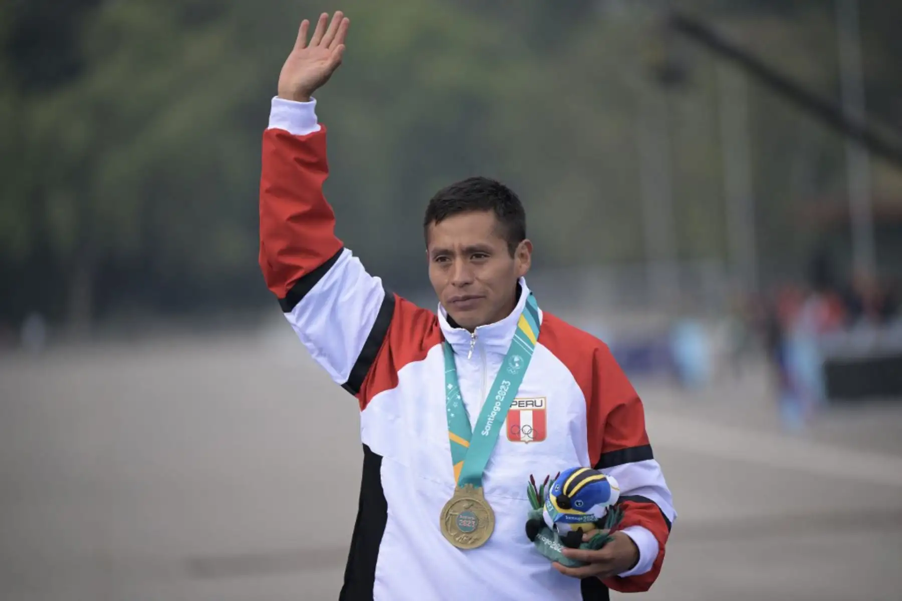 El peruano Cristhian Simeón Pacheco Mendoza ondea en el podio con su medalla de oro tras ganar la final masculina de maratón de los Juegos Panamericanos Santiago 2023 en Santiago. Foto: AFP