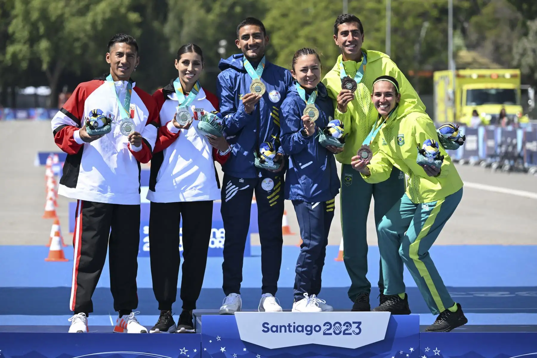 César Rodríguez y Kimberly García de Perú, Bryan Pintado y Glenda Morejón de Ecuador, y Caio Bonfim y Viviane Santana de Brasil posan con las medallas de plata, oro y bronce, respectivamente, durante la ceremonia del podio de la final de relevos mixtos de marcha de maratón. de los Juegos Panamericanos Santiago 2023 en la Explanada Campo de Marte de Santiago el 4 de noviembre de 2023. Foto: ANDINA/AFP