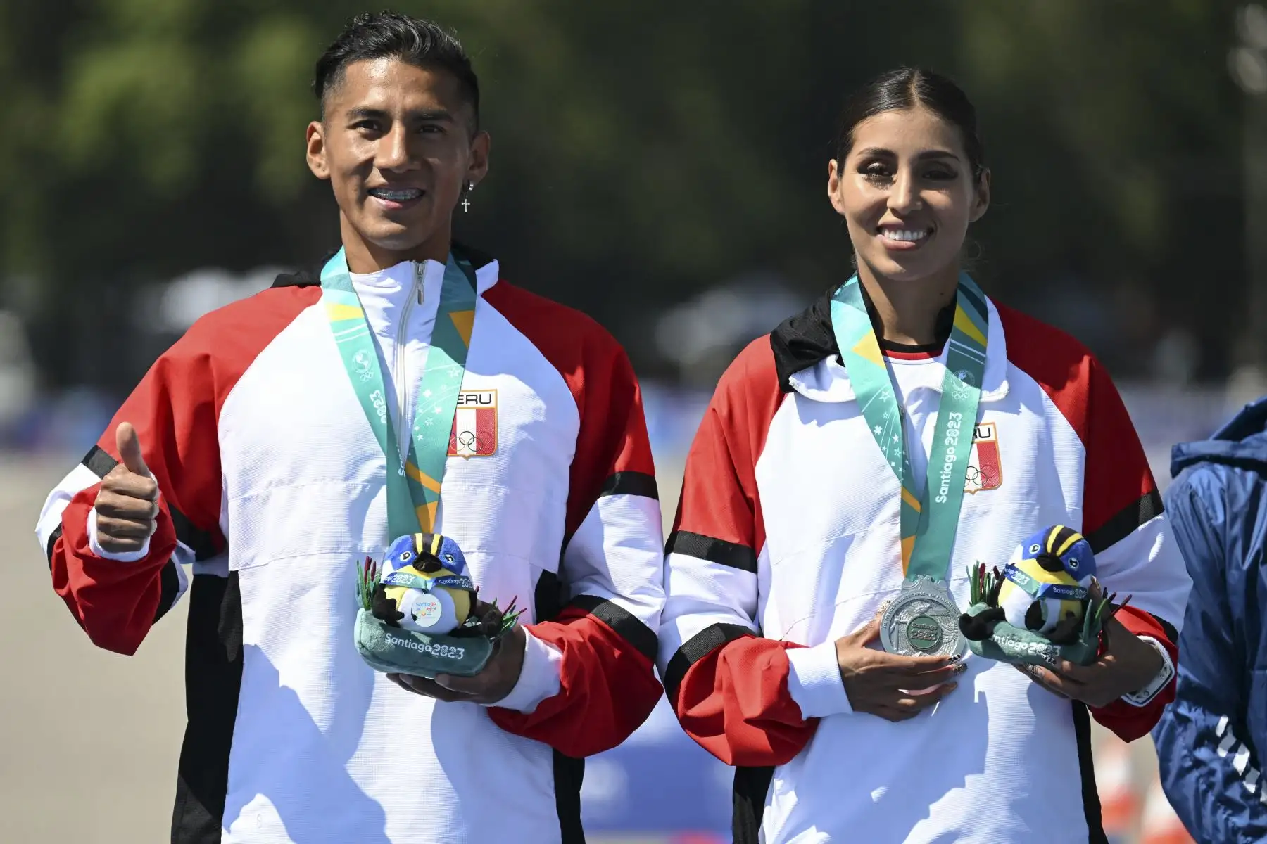 César Rodríguez y Kimberly García de Perú posan con la medalla de plata durante la ceremonia del podio de la final de relevos mixtos de caminata de maratón de los Juegos Panamericanos Santiago 2023 en la Explanada Campo de Marte en Santiago el 4 de noviembre de 2023. Foto: ANDINA/AFP
