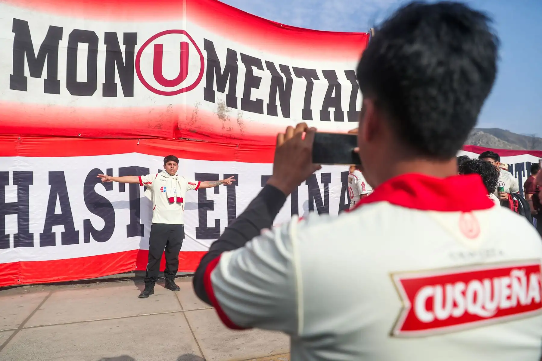 Hinchas de Universitario de Deportes alientan a su equipo previo al partido ante el club Alianza Lima por la primera final de la Liga 1 en el Clásico del fútbol peruano en el estadio Monumental de Ate.
Foto: ANDINA/ Ricardo Cuba
