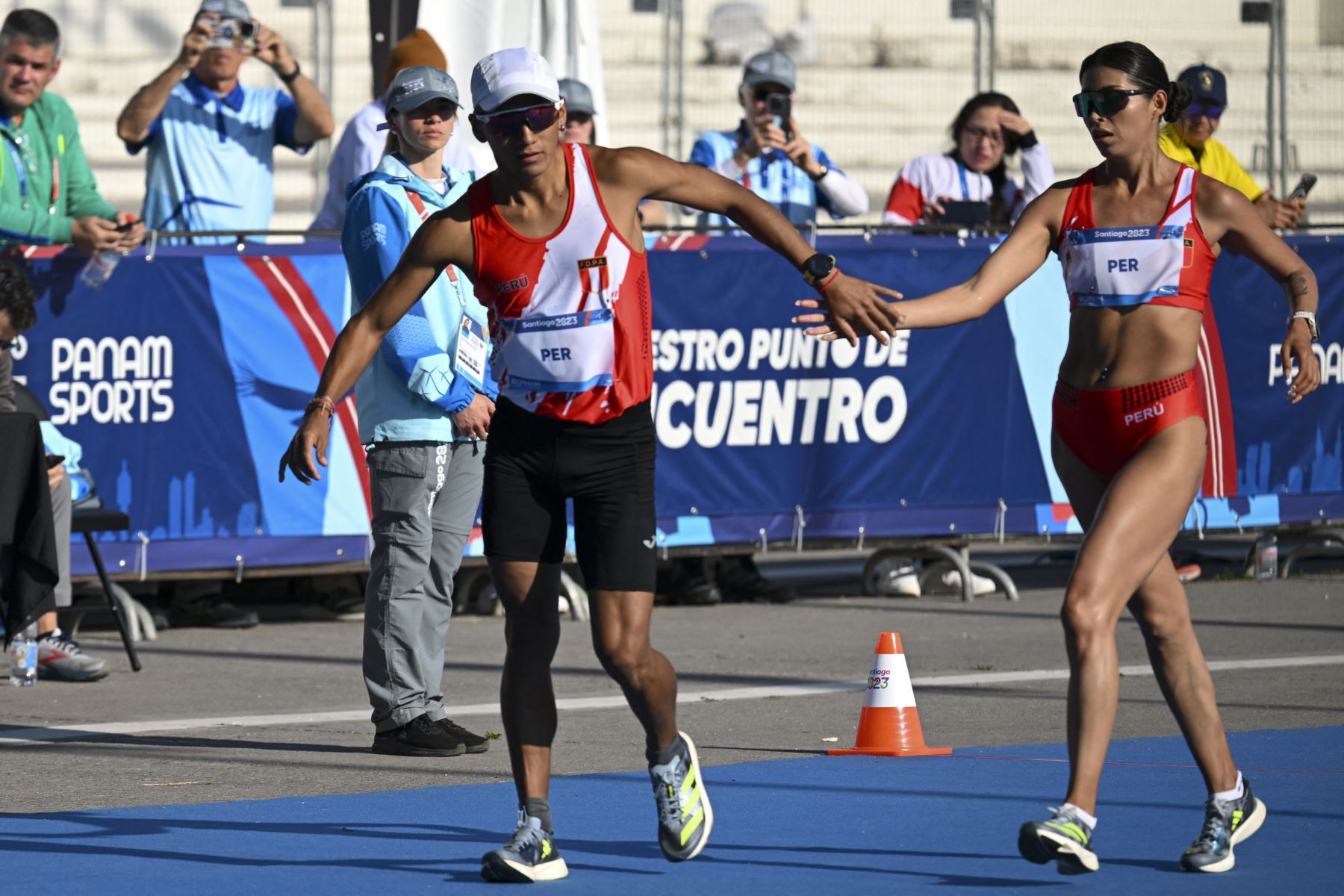 César Augusto Rodríguez Diburga de Perú reemplaza a Kimberly García durante la final de relevos mixtos de marcha maratón de los Juegos Panamericanos Santiago 2023. Foto: AFP