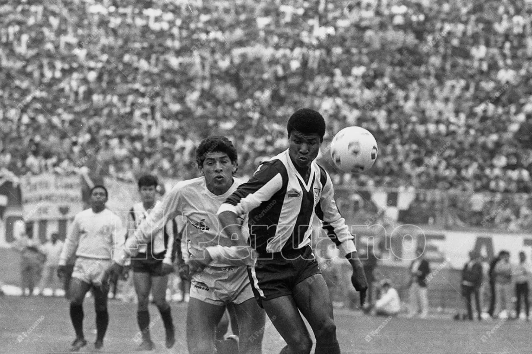 Lima - 1 noviembre 1987 / El delantero aliancista Luis Escobar supera a José Luis Carranza en el encuentro entre Alianza Lima y Universitario. El cuadro aliancista ganó el clásico 1-0 con gol del "Potrillo" Escobar. Foto: Diario Oficial El Peruano / Rómulo Luján