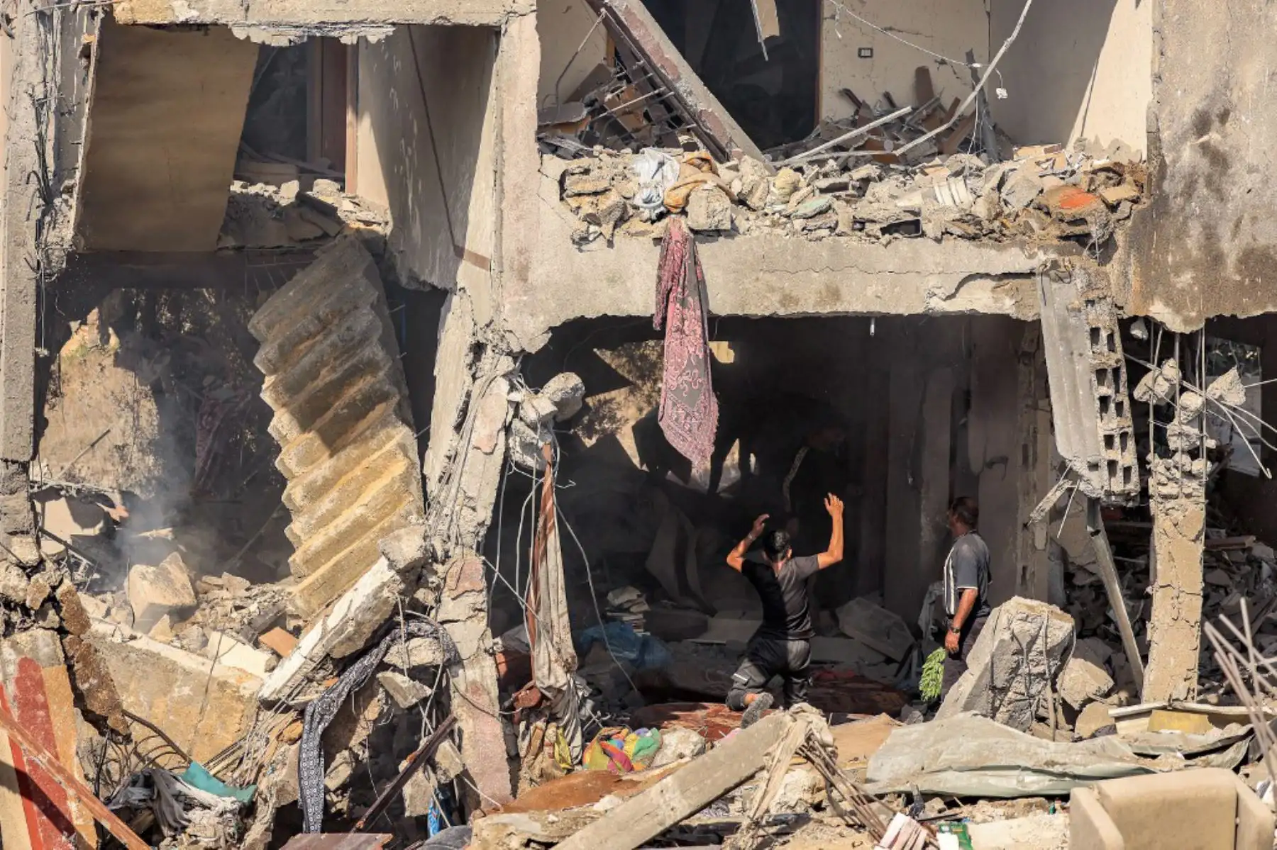 La gente busca supervivientes y los cuerpos de las víctimas entre los escombros de un edificio que fue alcanzado por un bombardeo israelí en Khan Yunis, en el sur de la Franja de Gaza. Foto: AFP