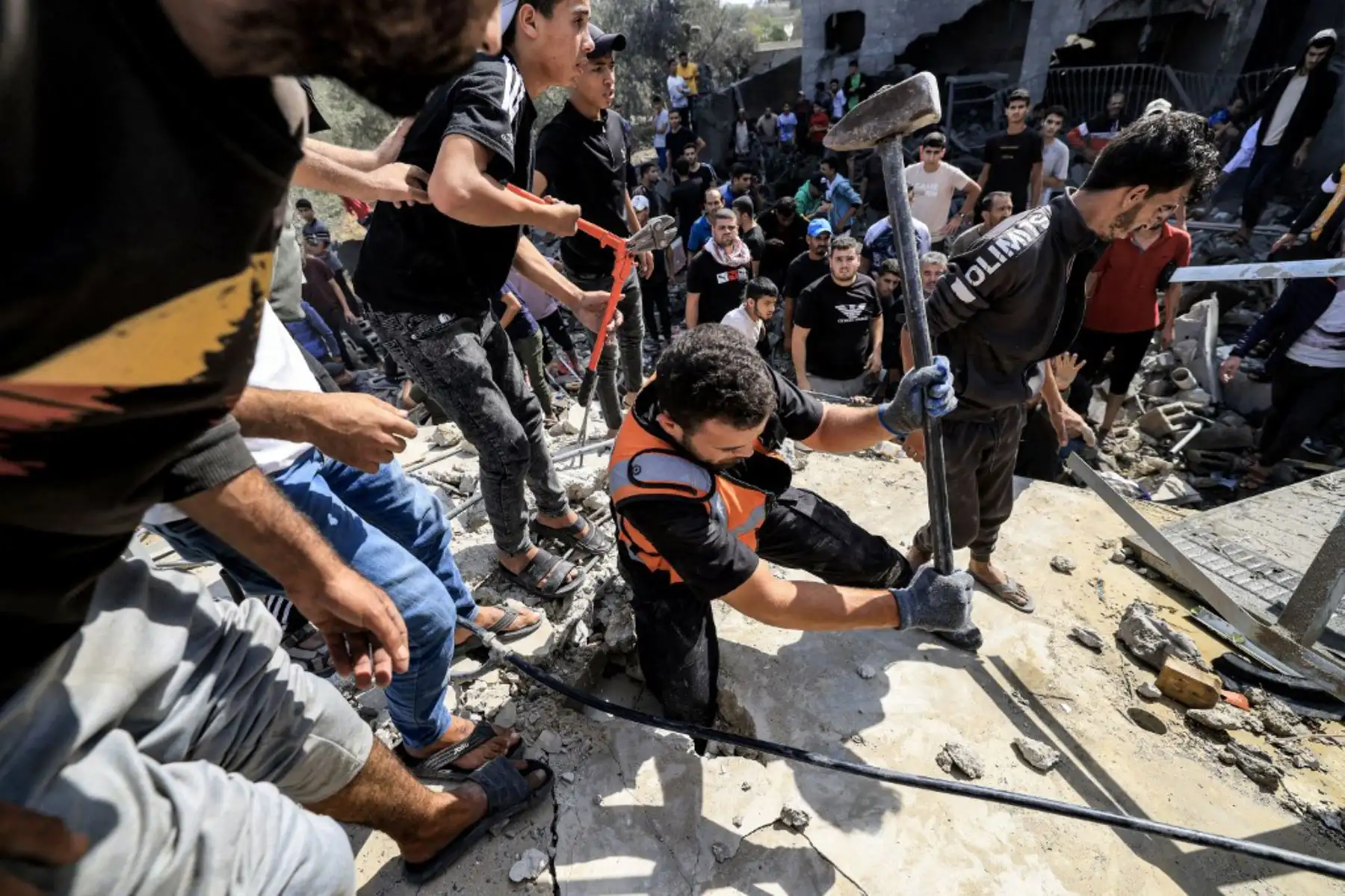 La gente busca supervivientes y los cuerpos de las víctimas entre los escombros de un edificio que fue alcanzado por un bombardeo israelí en Khan Yunis, en el sur de la Franja de Gaza. Foto: AFP