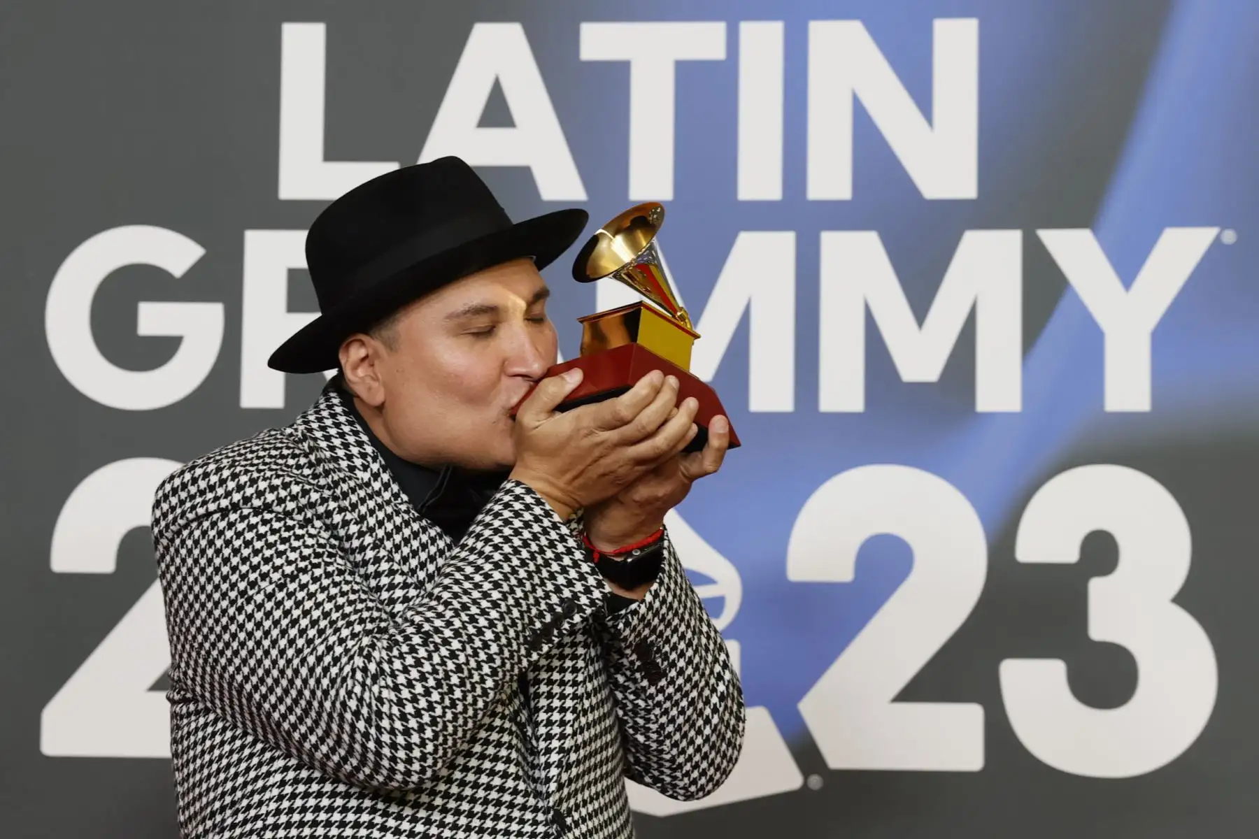 El músico mexicano Juan Treviño besa el premio al Mejor Álbum Tejano, durante la gala anual de los Latin Grammy que se celebra este jueves en Sevilla. 
Foto:EFE