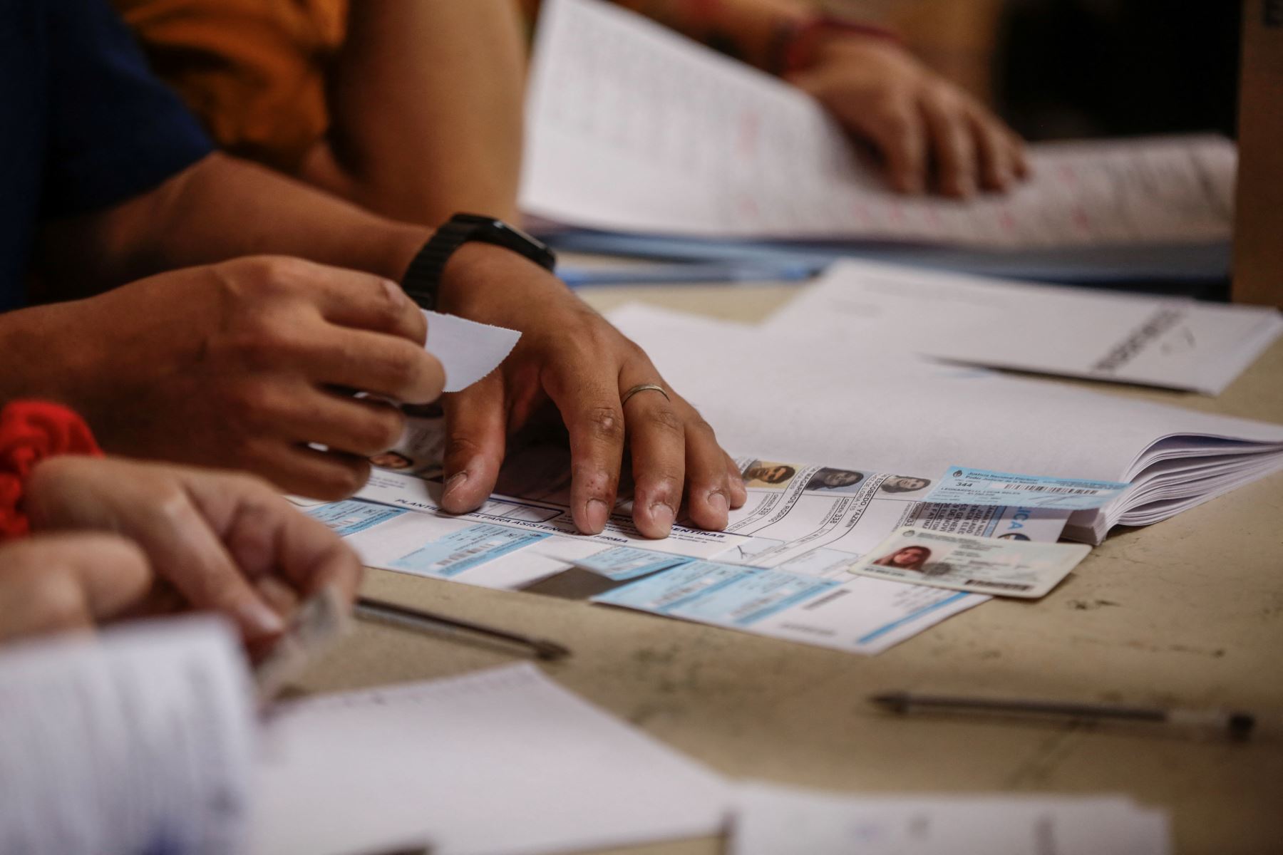 Un empleado electoral revisa una tarjeta de identificación en un colegio electoral en Buenos Aires, durante la segunda vuelta de las elecciones presidenciales el 19 de noviembre de 2023.
Foto: AFP