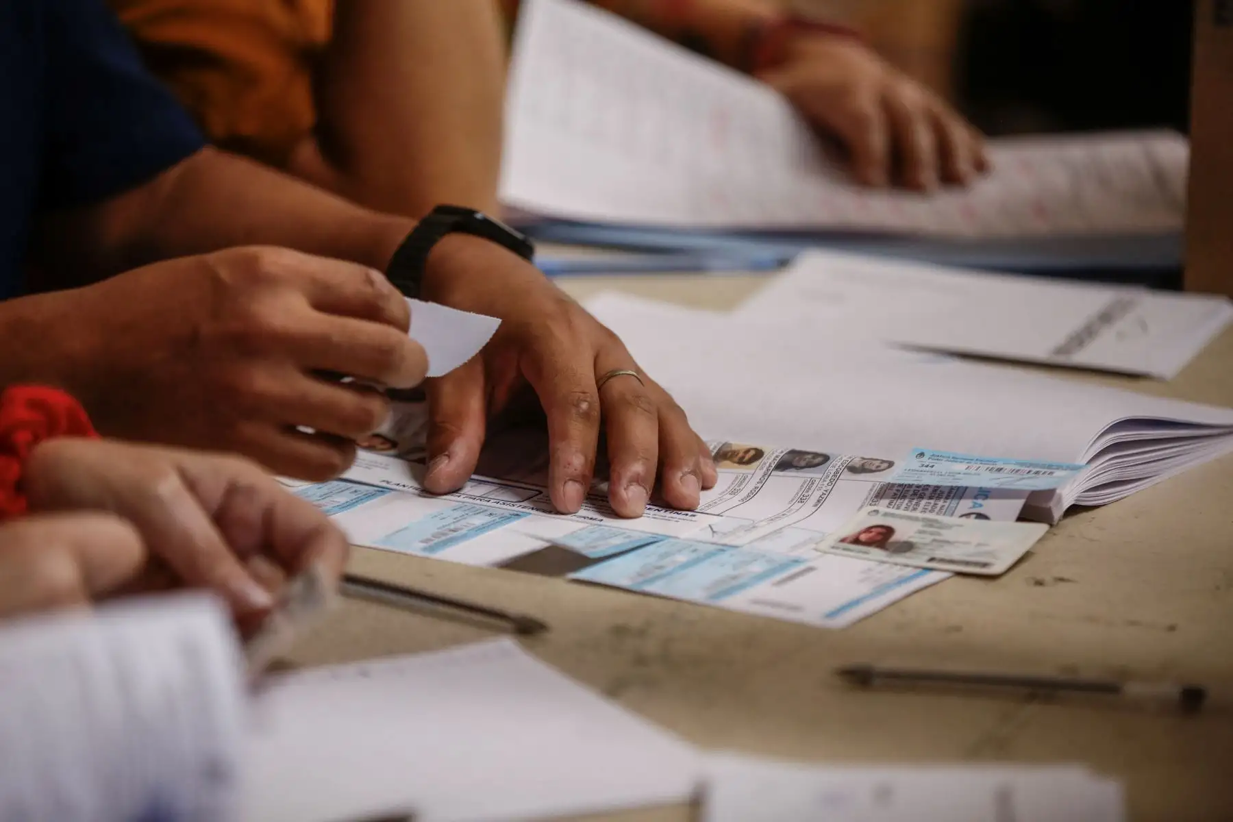 Un empleado electoral revisa una tarjeta de identificación en un colegio electoral en Buenos Aires, durante la segunda vuelta de las elecciones presidenciales el 19 de noviembre de 2023.
Foto: AFP