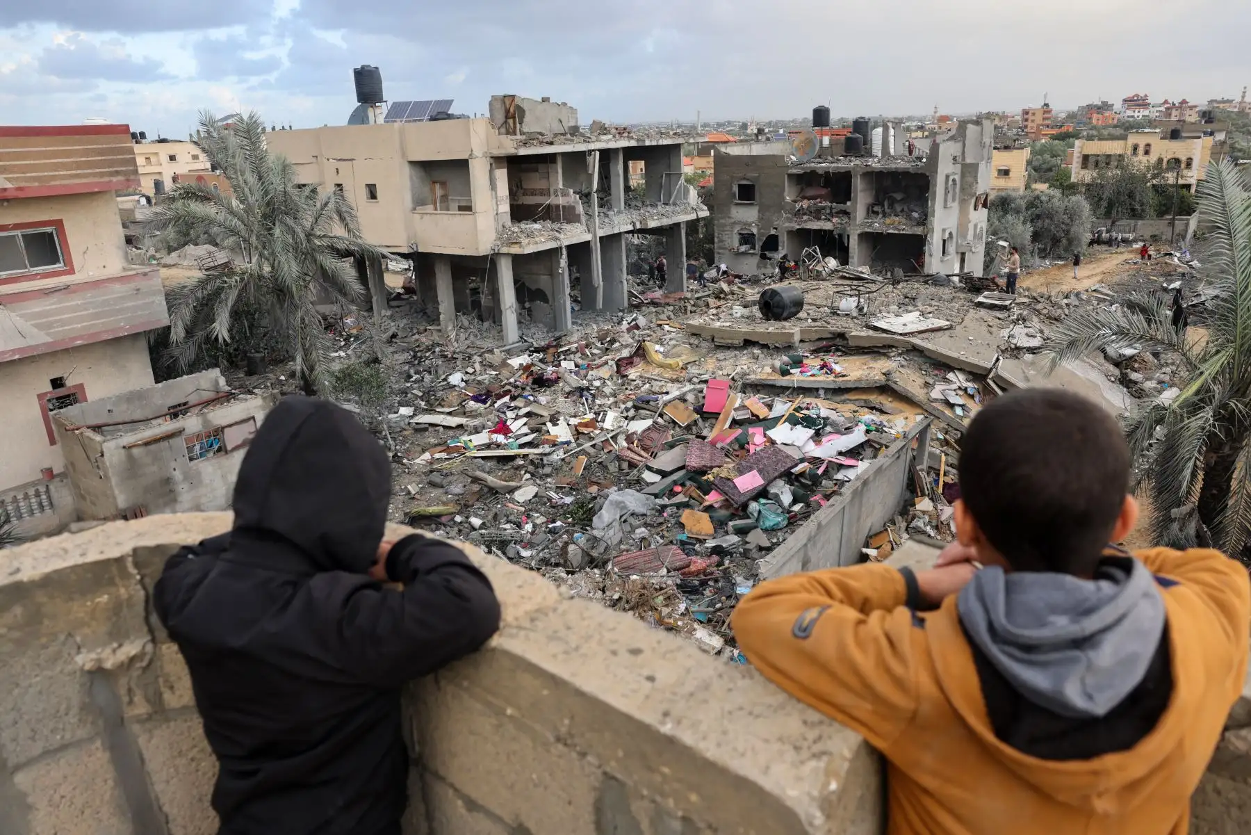 Dos personas observan los edificios en escombros en la ciudad de Rafah, en el sur de la Franja de Gaza. Foto: AFP