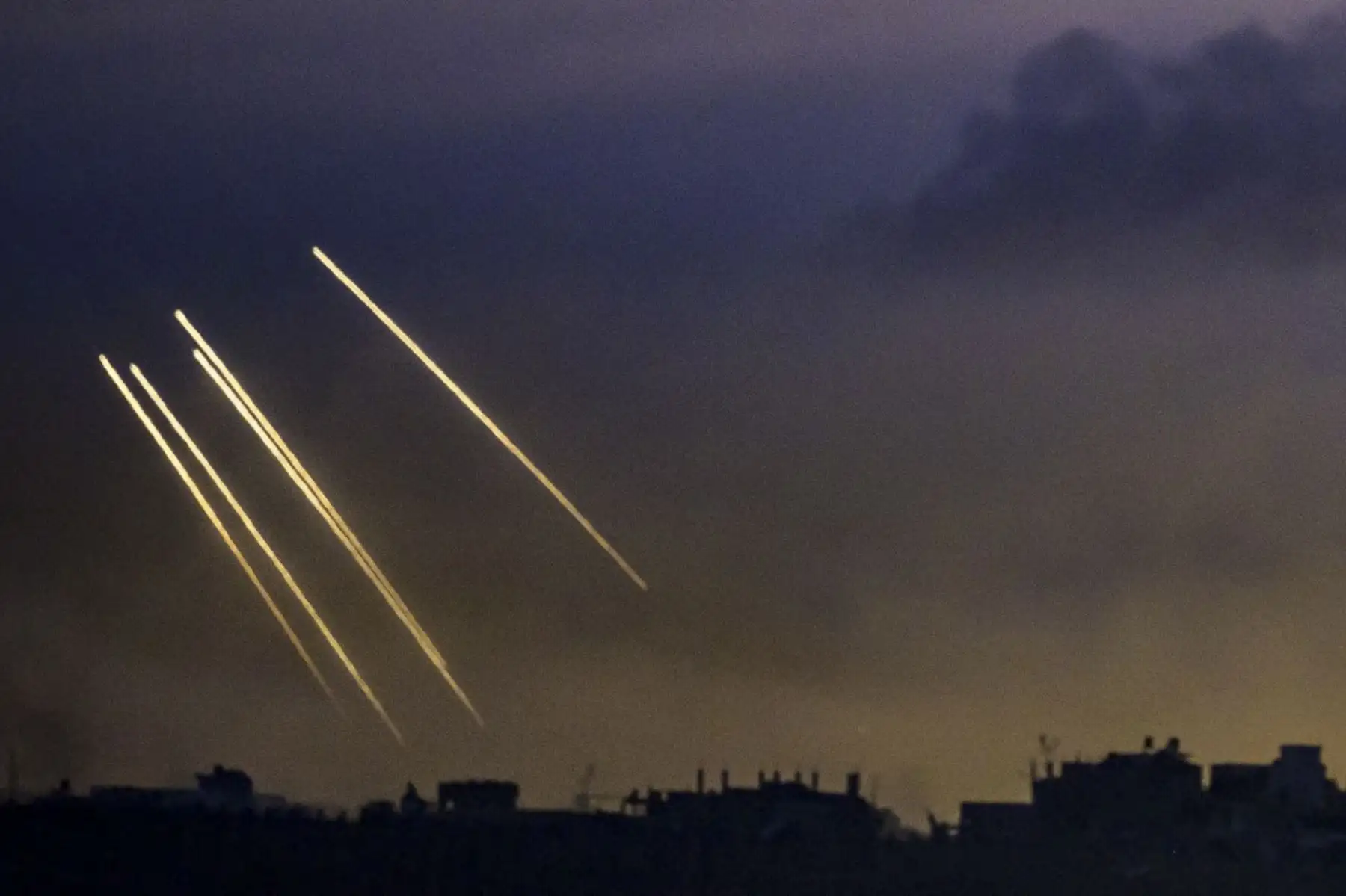 Esta fotografía de larga exposición tomada desde el sur de Israel, cerca de la frontera con la Franja de Gaza, muestra municiones de humo israelíes disparadas por tropas israelíes en la parte norte del enclave palestino el 22 de noviembre de 2023, en medio de batallas en curso entre Israel y el movimiento palestino Hamas. Foto: ANDINA/AFP