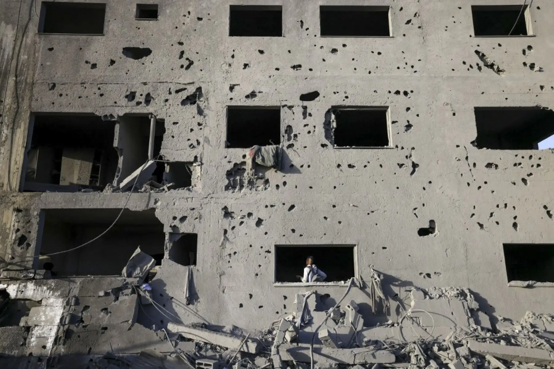 Un joven palestino camina dentro de un edificio plagado de metralla y dañado en un ataque israelí en Khan Yunis, en el sur de la Franja de Gaza, el 23 de noviembre de 2023, en medio de continuas batallas entre Israel y el grupo militante palestino Hamás. Foto: ANDINA/AFP