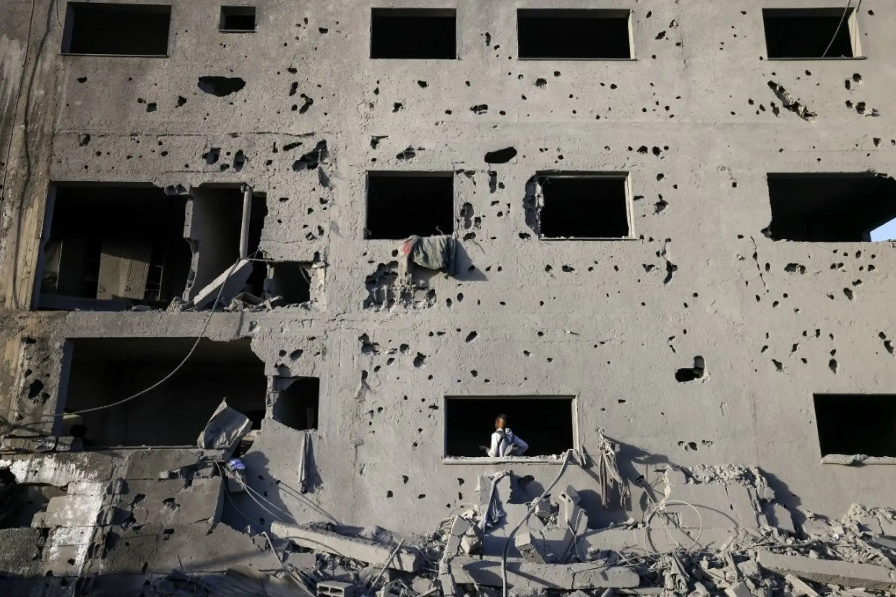 Un joven palestino camina dentro de un edificio dañado por un ataque israelí en Khan Yunis, en el sur de la Franja de Gaza, el 23 de noviembre de 2023, en medio de continuas batallas entre Israel y el grupo palestino Hamás. Foto: AFP