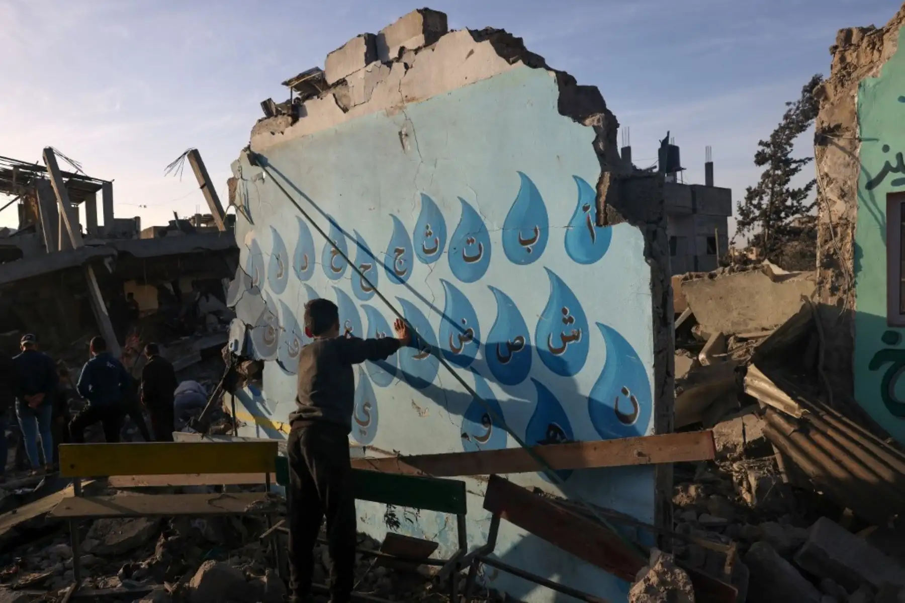 Un niño entre los escombros de una escuela atacada por las fuerzas  israelíes antes del inicio de una tregua de cuatro días en las batallas entre Israel y militantes de Hamás, en Rafah, en el sur de la Franja de Gaza, el 24 de noviembre de 2023. Foto: AFP