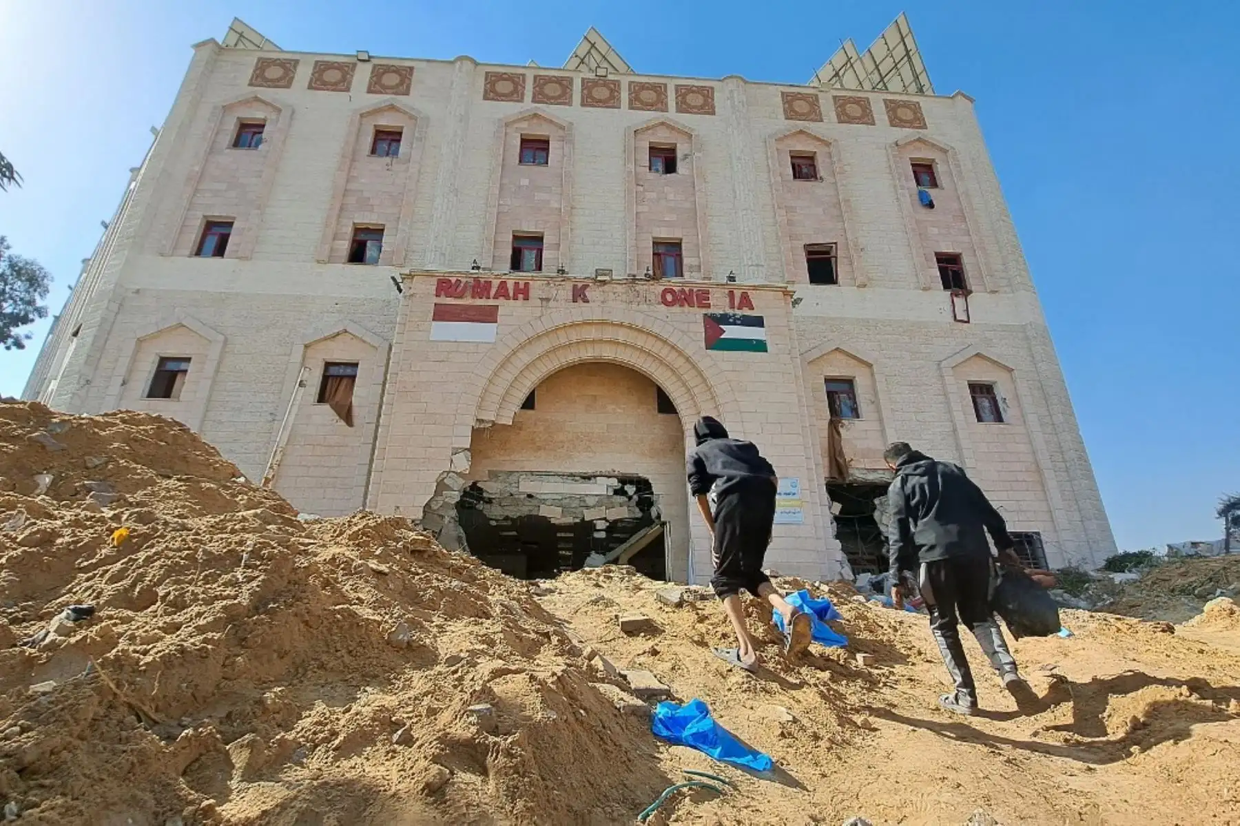 Personas caminan hacia el hospital indonesio en el borde del campo de refugiados de Jabalia, en el norte de la Franja de Gaza, después de que, según versiones, las tropas israelíes atacaron el centro médico, el 24 de noviembre de 2023. Israel  ha afirmado que Hamás ha utilizado hospitales para ocultar instalaciones subterráneas de mando y control. Foto: AFP