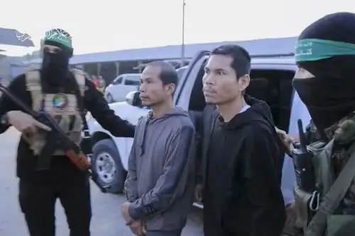 Una imagen tomada de un vídeo publicado por la Oficina de Medios de Hamás muestra a miembros de sus Brigadas Al-Qassam llevando rehenes a funcionarios del Comité Internacional de la Cruz Roja en Gaza el 24 de noviembre de 2023, antes de su traslado a Israel. Foto: AFP
