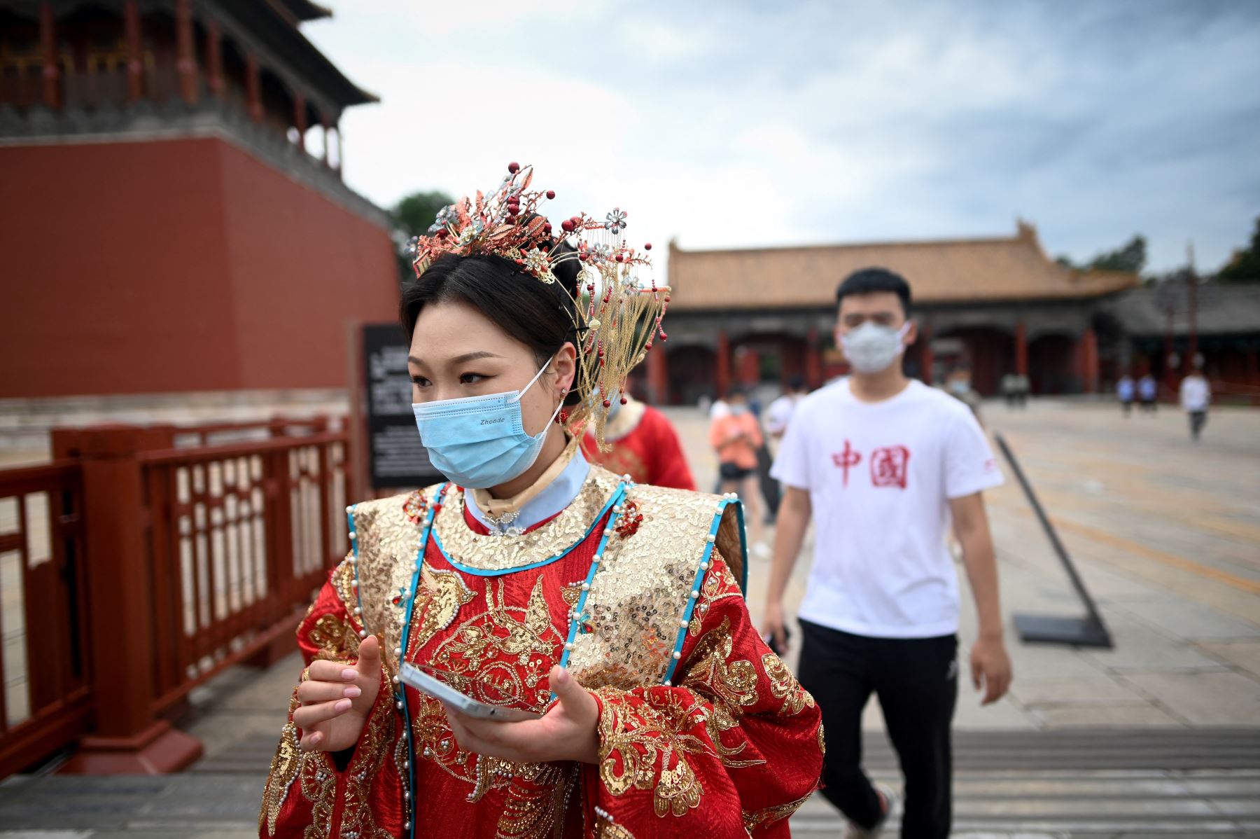 Una mujer, vestida con el vestido de transición chino, conocido como Hanfu, se prepara para visitar la Ciudad Prohibida en Beijing el 7 de junio de 2022, después de que el gobierno alivió algunas restricciones de Covid-19 y la mayoría de los museos se reanudaron en la ciudad. Foto: AFP