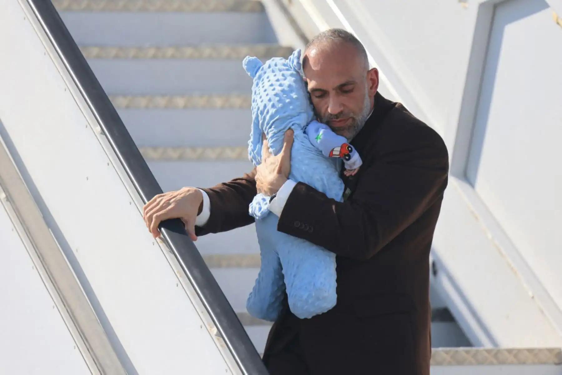 Los palestinos evacuados de la Franja de Gaza que llegaron en un avión desde el aeropuerto egipcio de El-Arish desembarcan al aterrizar en Abu Dhabi. Foto: AFP