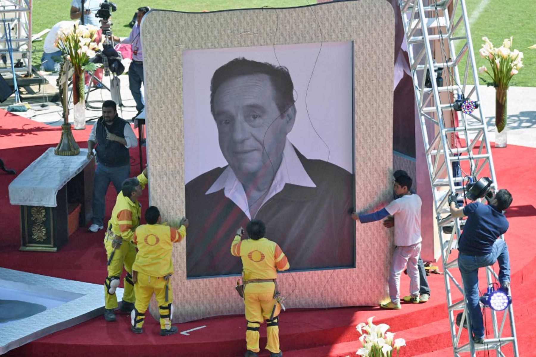 Trabajadores sostienen un retrato del icónico comediante de televisión mexicano Roberto Gómez Bolaños, antes de un homenaje en su honor dos días después de su muerte, el 30 de noviembre de 2014 en el estadio Azteca con capacidad para 105.000 personas en la Ciudad de México. Foto: AFP