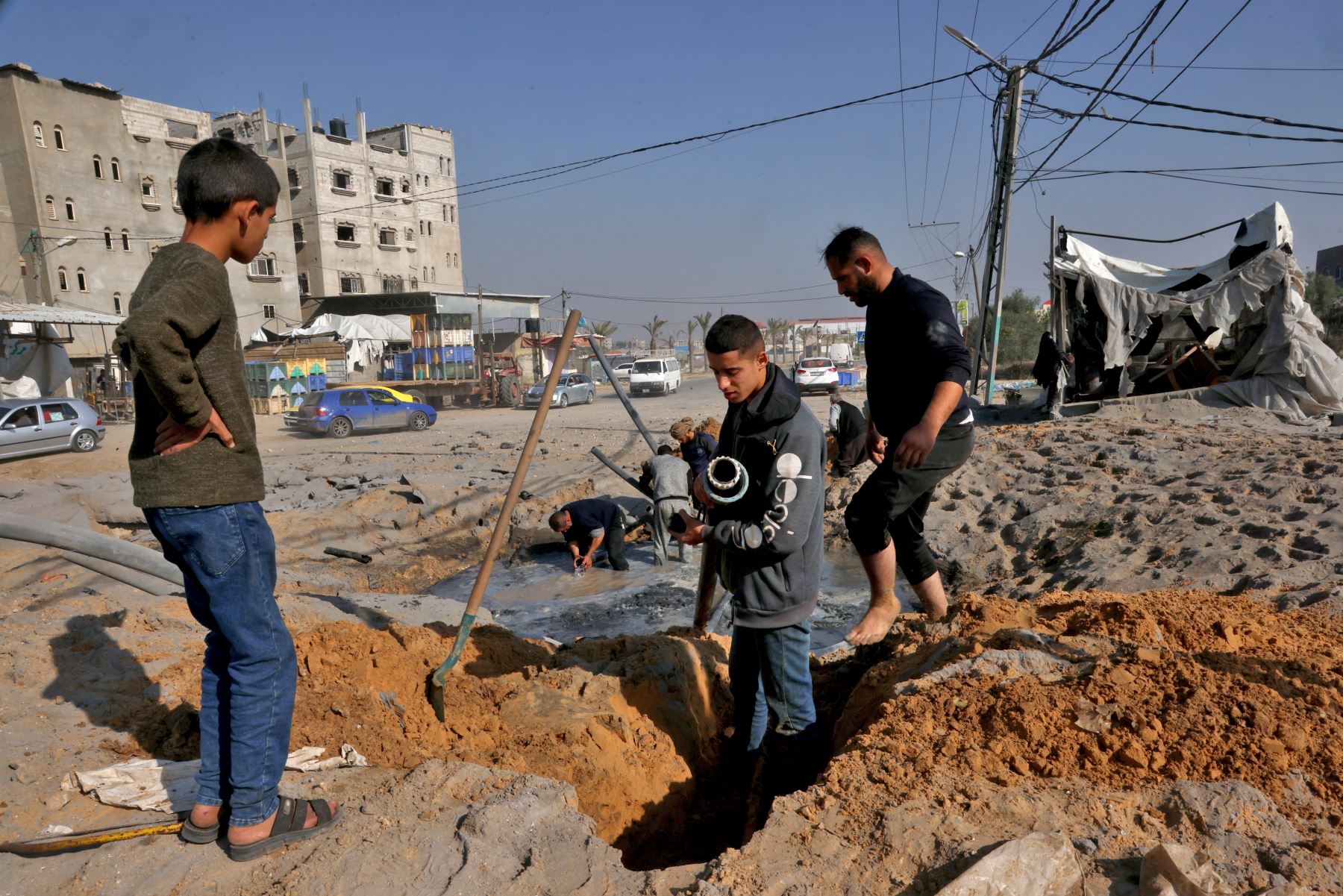Trabajadores palestinos reparan una tubería de agua dañada tras un ataque aéreo israelí en la carretera principal entre Rafah y Khan Yunis, en el sur de la Franja de Gaza.
Foto: AFP