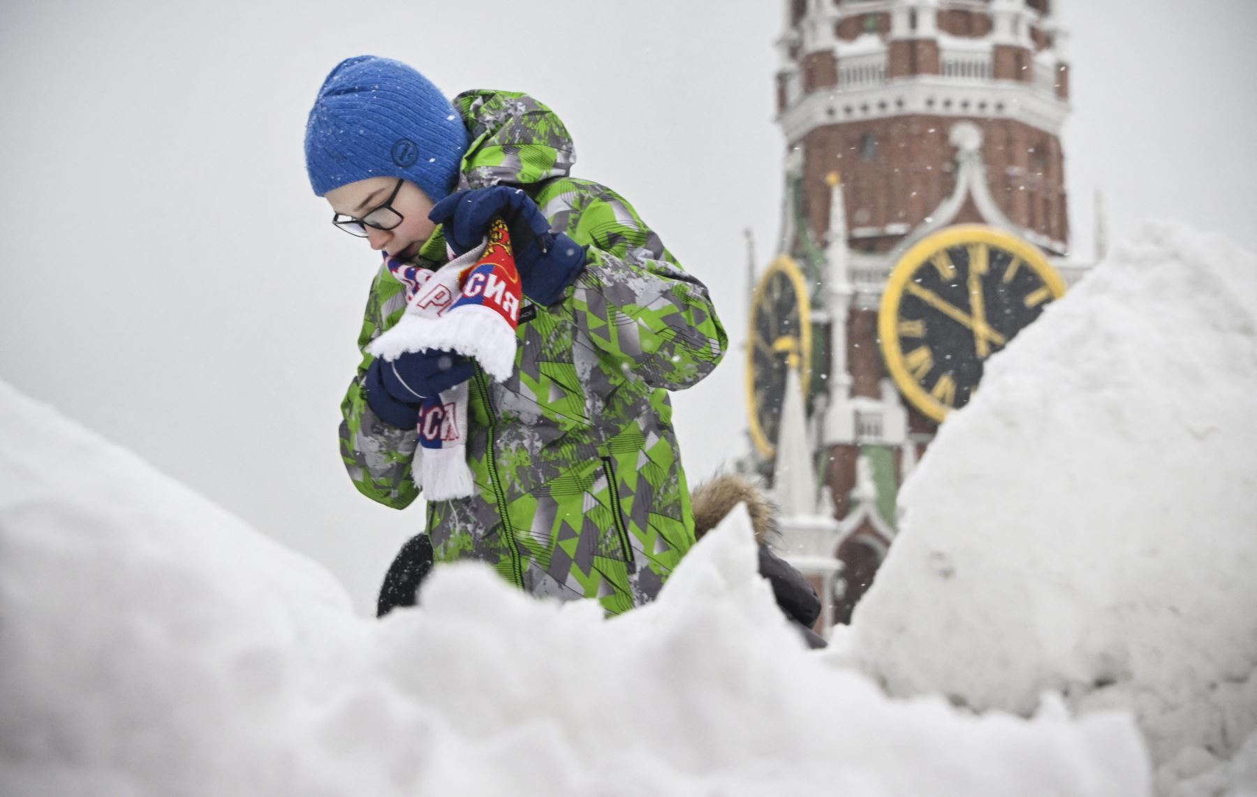Un niño juega en la cima de una colina nevada en la Plaza Roja frente a la torre Spasskaya del Kremlin después de una fuerte nevada en Moscú
Foto: AFP