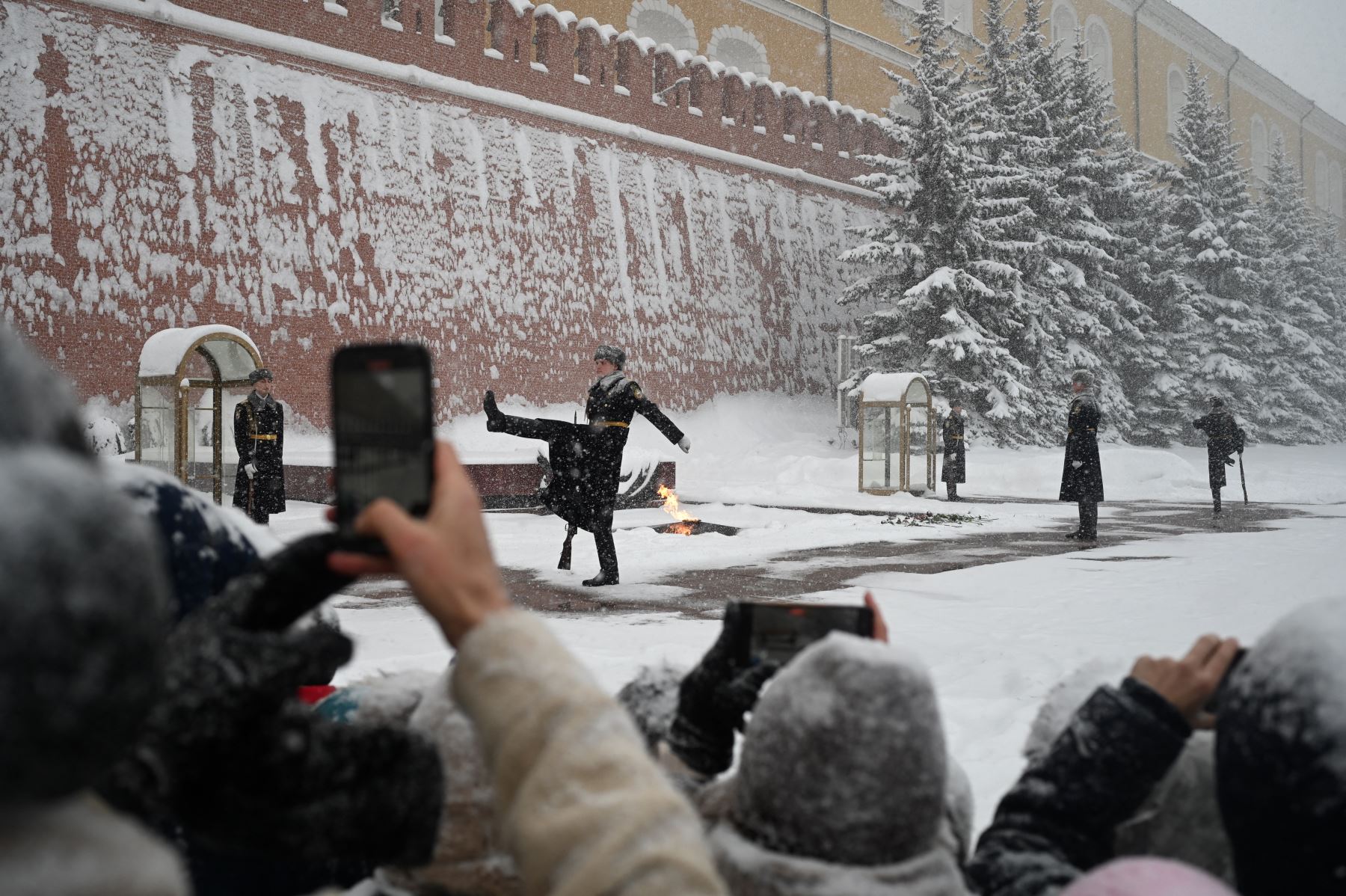 La gente toma fotografías de los guardias de honor rusos marchando ante la Tumba del Soldado Desconocido durante una nevada en Moscú. Foto: AFP