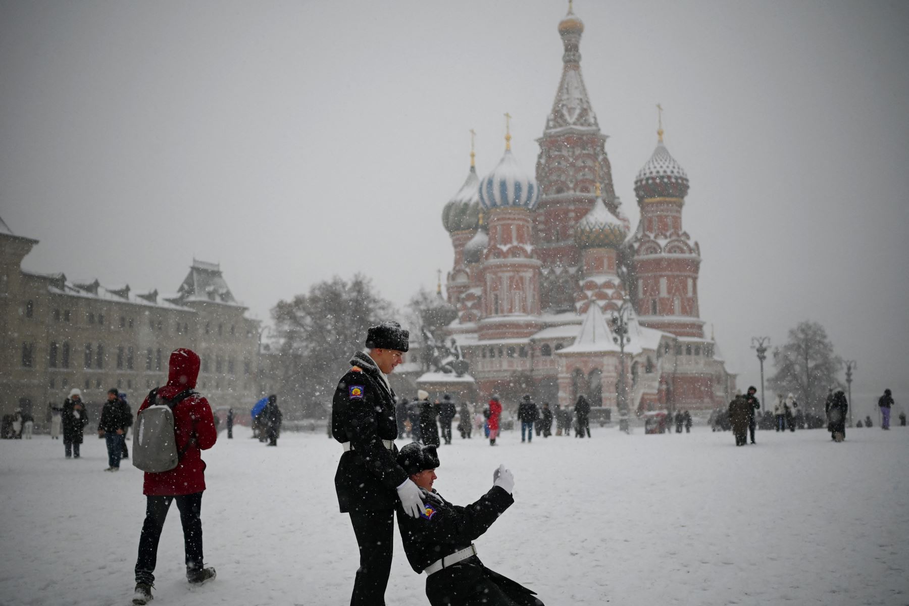 Los cadetes rusos posan para una selfie frente a la Catedral de San Basilio en la Plaza Roja cubierta de nieve en Moscú. Foto: AFP