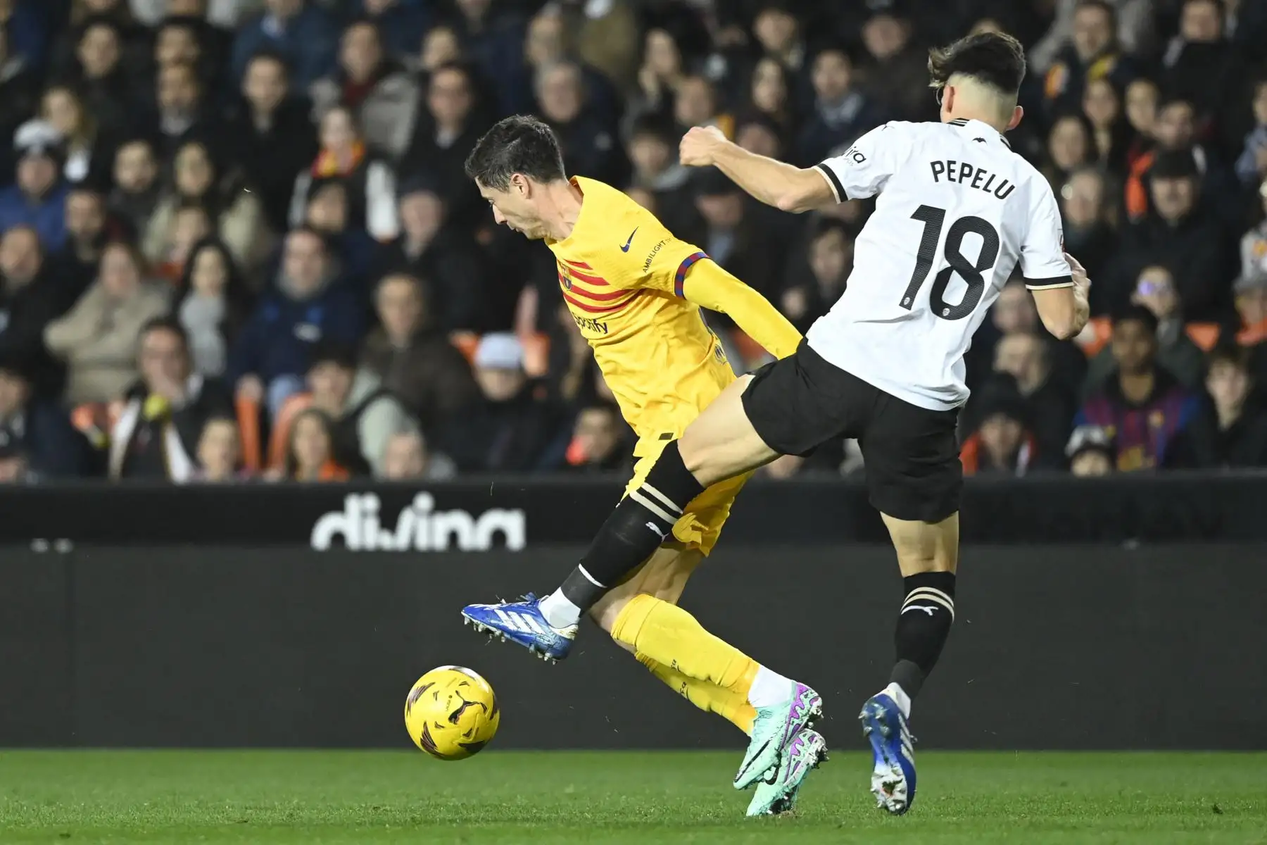 El delantero polaco del Barcelona, Robert Lewandowski compite con el centrocampista español del Valencia, José Luis García Vaya 
