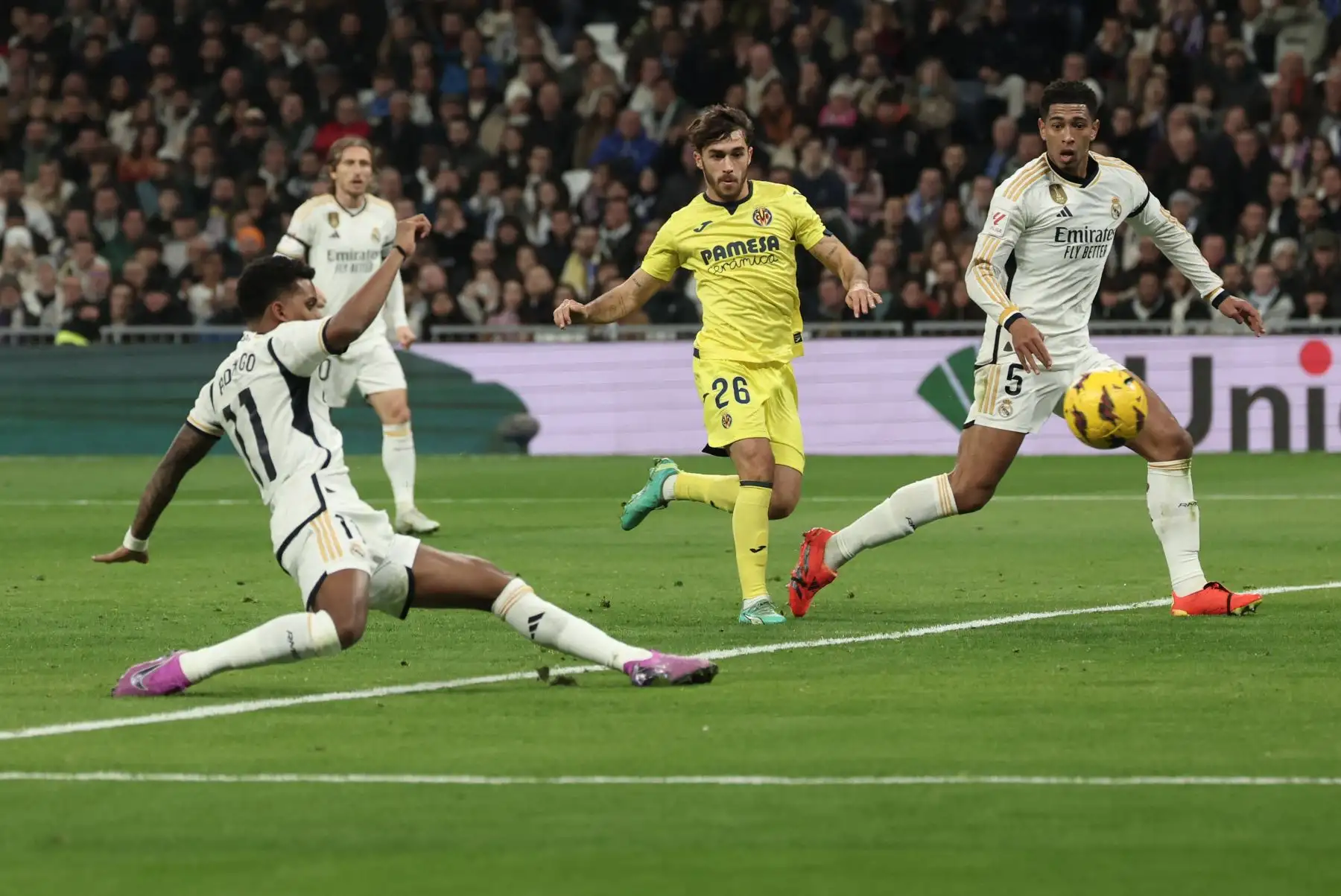 El delantero brasileño del Real Madrid, Rodrygo dispara el balón mientras el defensa español del Villarreal, Adria Altimira se acerca con el mediocampista inglés del Real Madrid, Jude Bellingham durante el partido de fútbol de la liga española entre el Real Madrid CF y el Villarreal CF en el estadio Santiago Bernabeu de Madrid.
Foto: AFP