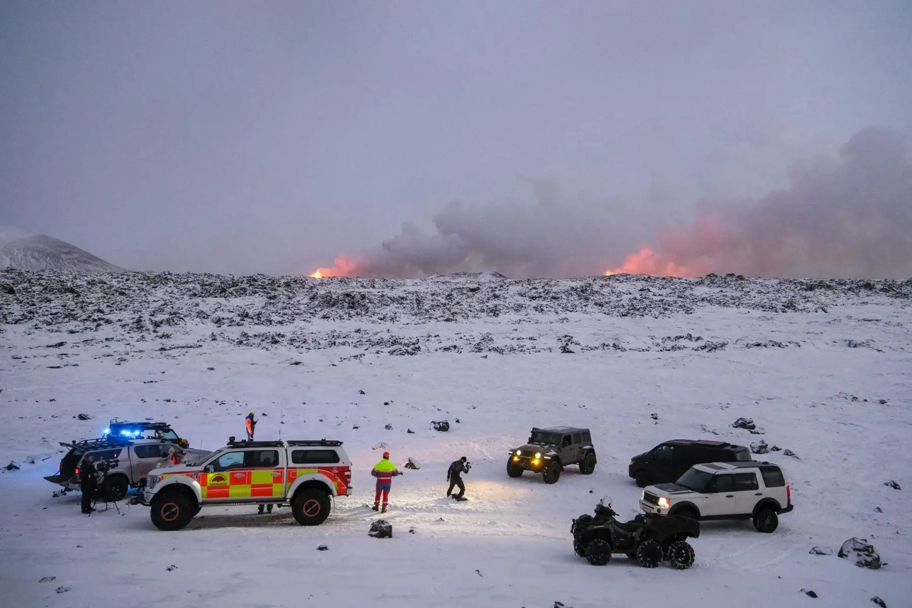 Miembros de un equipo de rescate se reúnen en una zona cercana a una erupción volcánica (trasera), cerca de la ciudad de Grindavik, en la península de Reykjanes, suroeste de Islandia, el 19 de diciembre de 2023. La Oficina Meteorológica de Islandia (OMI) anunció el inicio de una fisura volcánica erupción cerca del cráter Sundhnuka, al noreste de Grindavik, la noche del 18 de diciembre, tras semanas de intensa actividad sísmica en la zona. La potencia y la actividad sísmica de la erupción han disminuido con el tiempo, informó la OMI el 19 de diciembre, añadiendo que desde que comenzó la erupción se han registrado unos 320 terremotos.
Foto: EFE