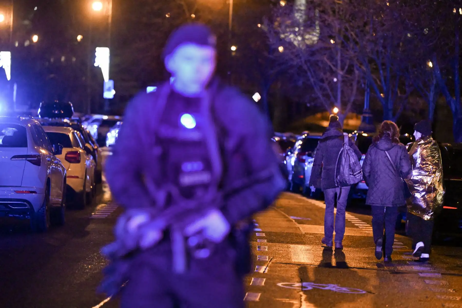 Las personas atrapadas en un tiroteo pasan junto a un policía armado cerca de la Universidad Carolina en el centro de Praga, el 21 de diciembre de 2023. El tiroteo en una universidad en el centro de Praga que mató a más de 15 personas no estuvo relacionado con el terrorismo internacional, el dijo el gobierno checo el jueves.
Foto: AFP