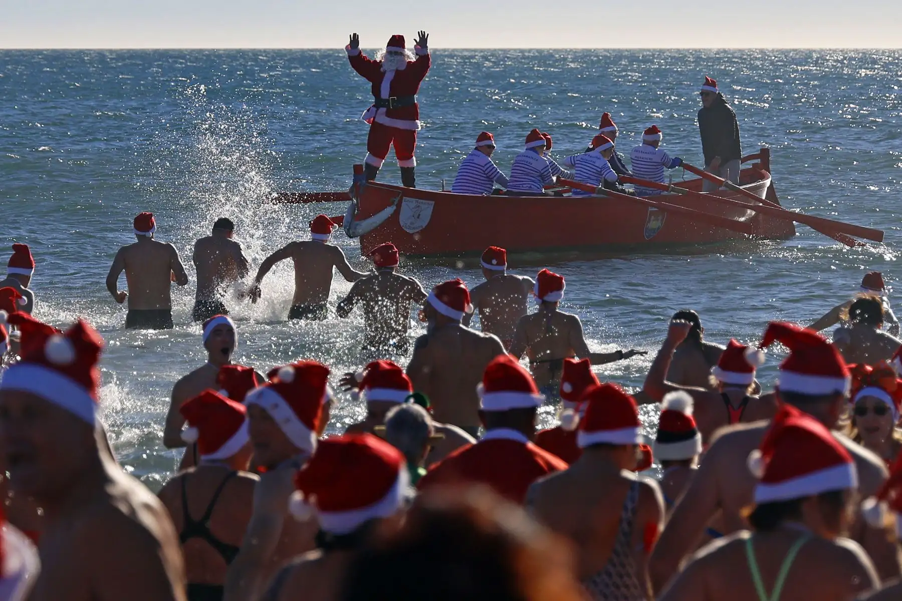 Cientos de personas disfrazadas de Papá Noel asisten al tradicional baño navideño de Valras, al sur de Francia, como antesala a las celebraciones de la Navidad. Foto: EFE
