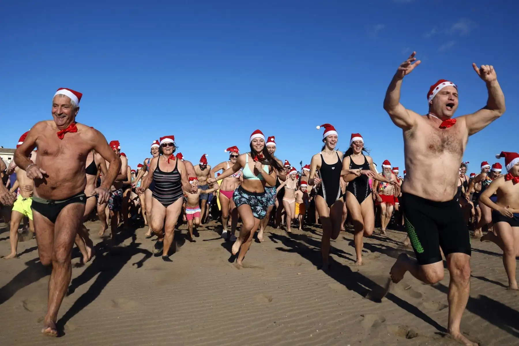 Cientos de personas disfrazadas de Papá Noel asisten al tradicional baño navideño de Valras, al sur de Francia, como antesala a las celebraciones de la Navidad. Foto: EFE