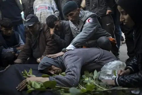 La madre de un palestino fallecido durante los ataques israelíes en el sur de Gaza llora junto a su cuerpo, frente al Hospital Nasser. Foto: EFE