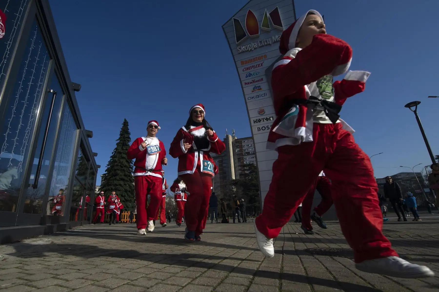 Personas vestidas como Papá Noel corren durante la tradicional carrera de Papá Noel en Skopje, República de Macedonia del Norte, en vísperas de celebrarse la Navidad. Foto: EFE