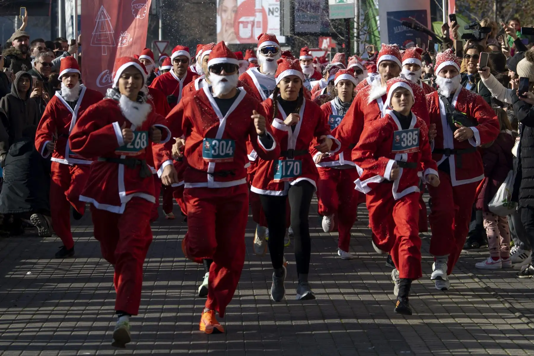 Personas vestidas como Papá Noel corren durante la tradicional carrera de Papá Noel en Skopje, República de Macedonia del Norte, en vísperas de celebrarse la Navidad. Foto: EFE