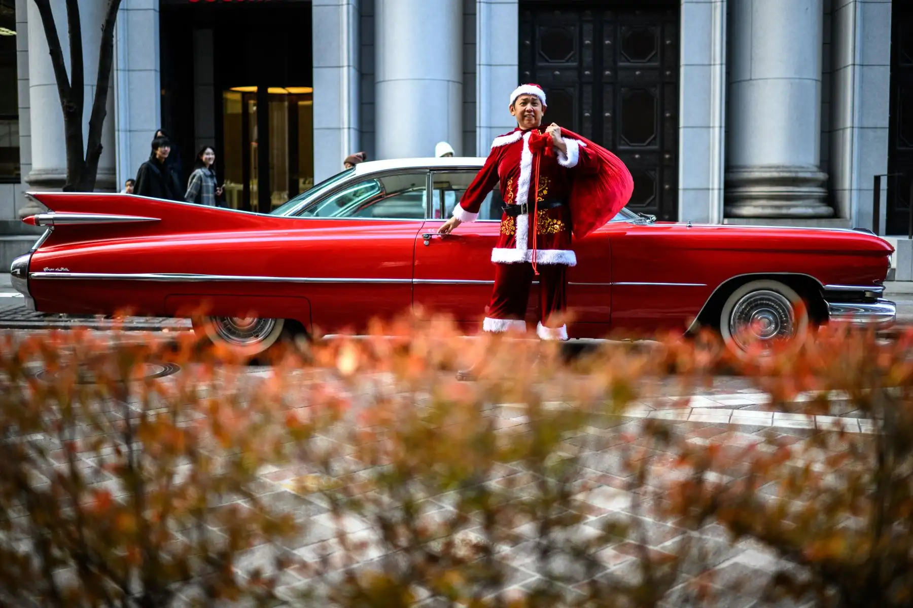 Hiroyuki Wada, miembro de un grupo de autos antiguos, vestido como Papá Noel, sostiene una bolsa de regalos de Navidad frente a su Cadillac de 1959 en el área de Marunouchi en Tokio.
Foto: AFP