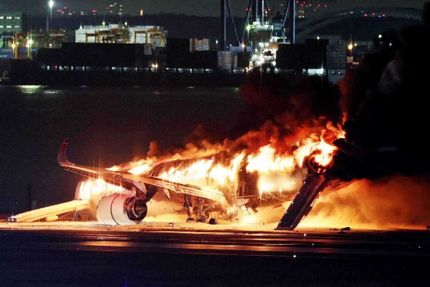Bomberos intentan extinguir un incendio en un avión de Japan Airlines en una pista del aeropuerto Haneda de Tokio. Foto: AFP
