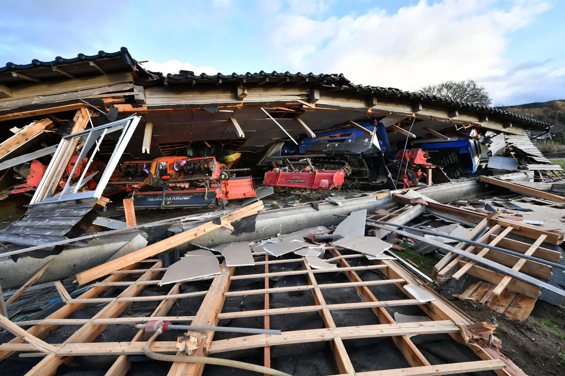 Se ve maquinaria agrícola y otros equipos atrapados bajo una casa de madera derrumbada en Wajima, prefectura de Ishikawa, el 2 de enero de 2024, un día después de que un gran terremoto de magnitud 7,5 sacudiera la región de Noto en la prefectura de Ishikawa por la tarde. Los rescatistas japoneses lucharon contra el reloj y contra poderosas réplicas el 2 de enero para encontrar sobrevivientes de un gran terremoto que se produjo el día de Año Nuevo y que, según se informa, mató a más de 20 personas y dejó un