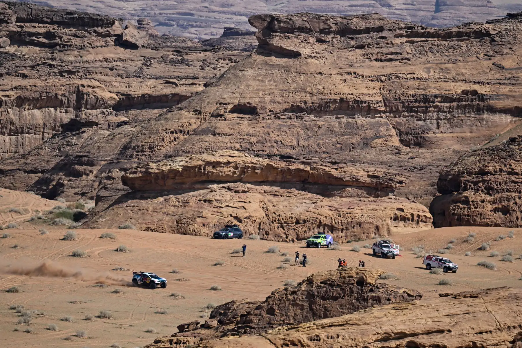 El piloto qatarí de Prodrive, Nasser Al-Attiyah, y su copiloto francés, Mathieu Baumel, conducen su coche (izq.) durante la etapa prólogo antes del rally Dakar 2024 en Al-Ula, Arabia Saudita. Foto. ANDINA/AFP
