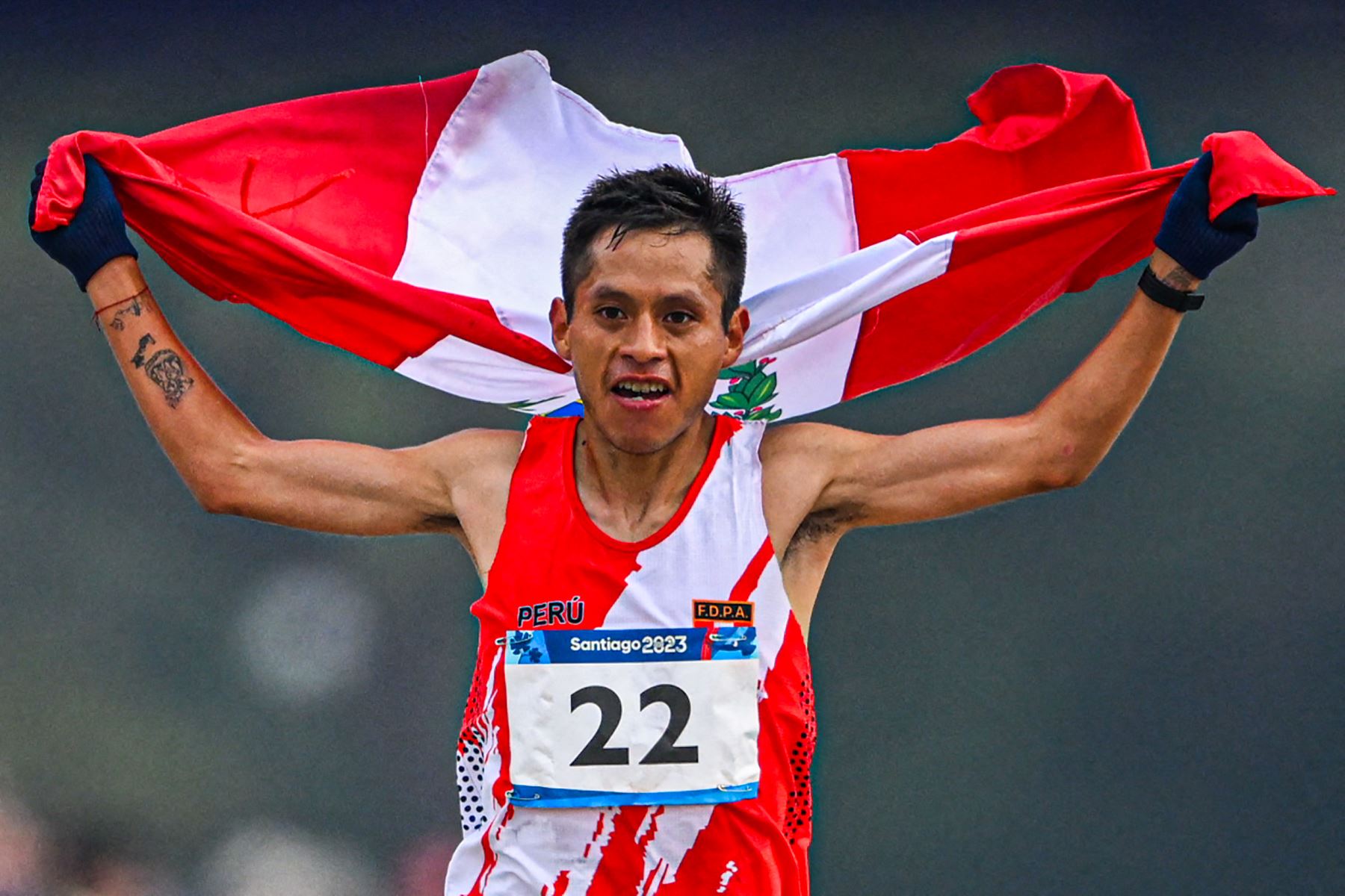 Cristhian Simeón Pacheco Mendoza de Perú muestra su bandera nacional luego de cruzar la línea de meta en primer lugar durante la final del maratón masculino de los Juegos Panamericanos Santiago 2023, en el Estadio Nacional, en Santiago.Foto: AFP