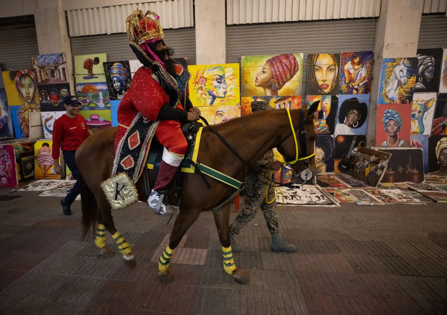Personas participan en la tradicional cabalgata de los Reyes Magos, en Santo Domingo (República Dominicana). La actividad, organizada por el Cuerpo de Bomberos del Distrito Nacional en colaboración con la Alcaldía, recorrió diversas calles de la Zona Colonial ante la alegría de los presentes. 
Foto: EFE