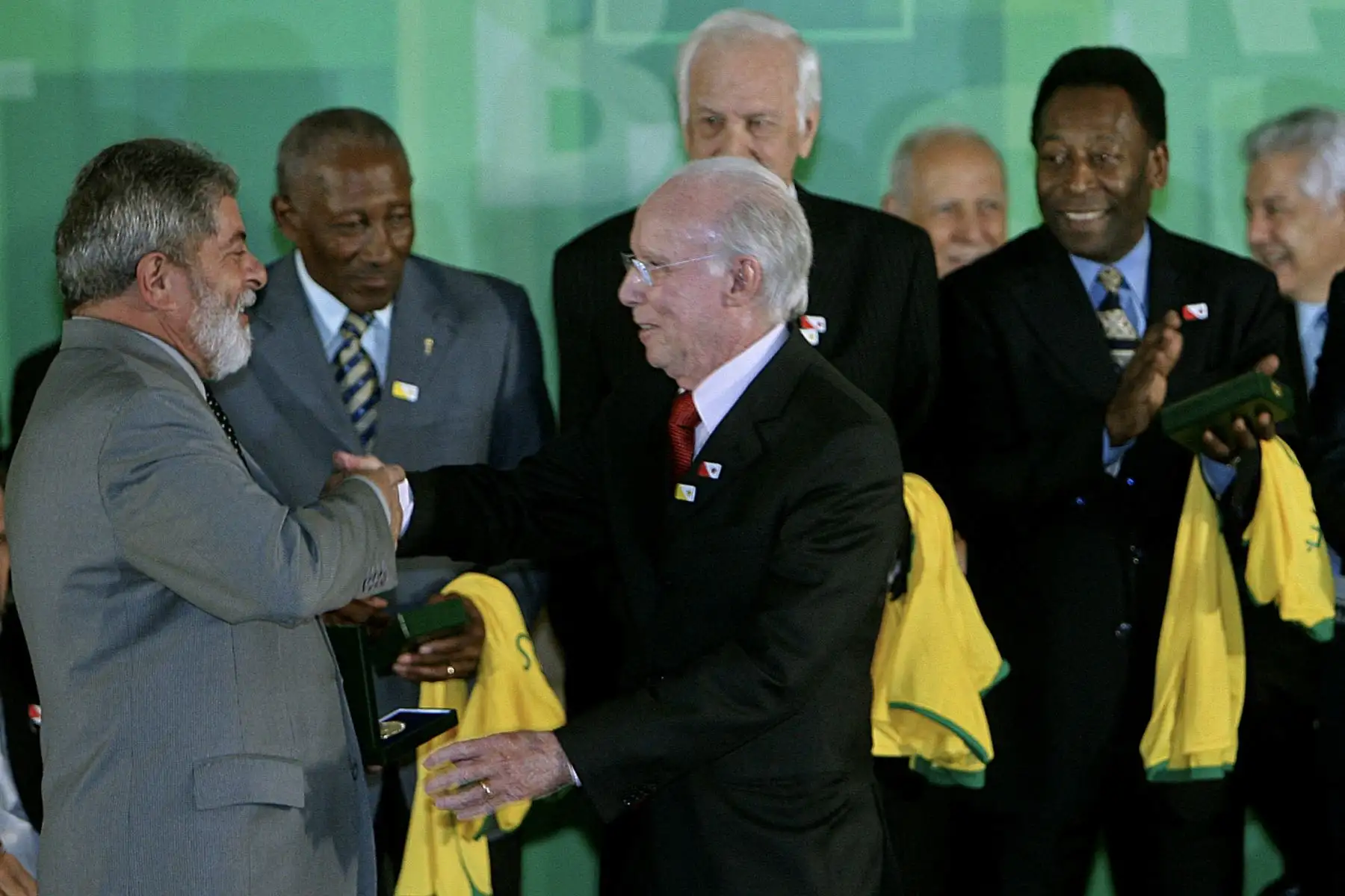 El presidente brasileño Luiz Inácio Lula da Silva  felicita al exfutbolista brasileño Mario "Lobo" Zagallo mientras la estrella del fútbol Pelé, observa, mientras condecora a los ganadores de la Copa Mundial de 1958, durante la ceremonia de apertura de una exposición que celebra el 50º aniversario de la primera victoria de Brasil en este torneo, en el Palacio Planalto de Brasilia.
Foto: AFP