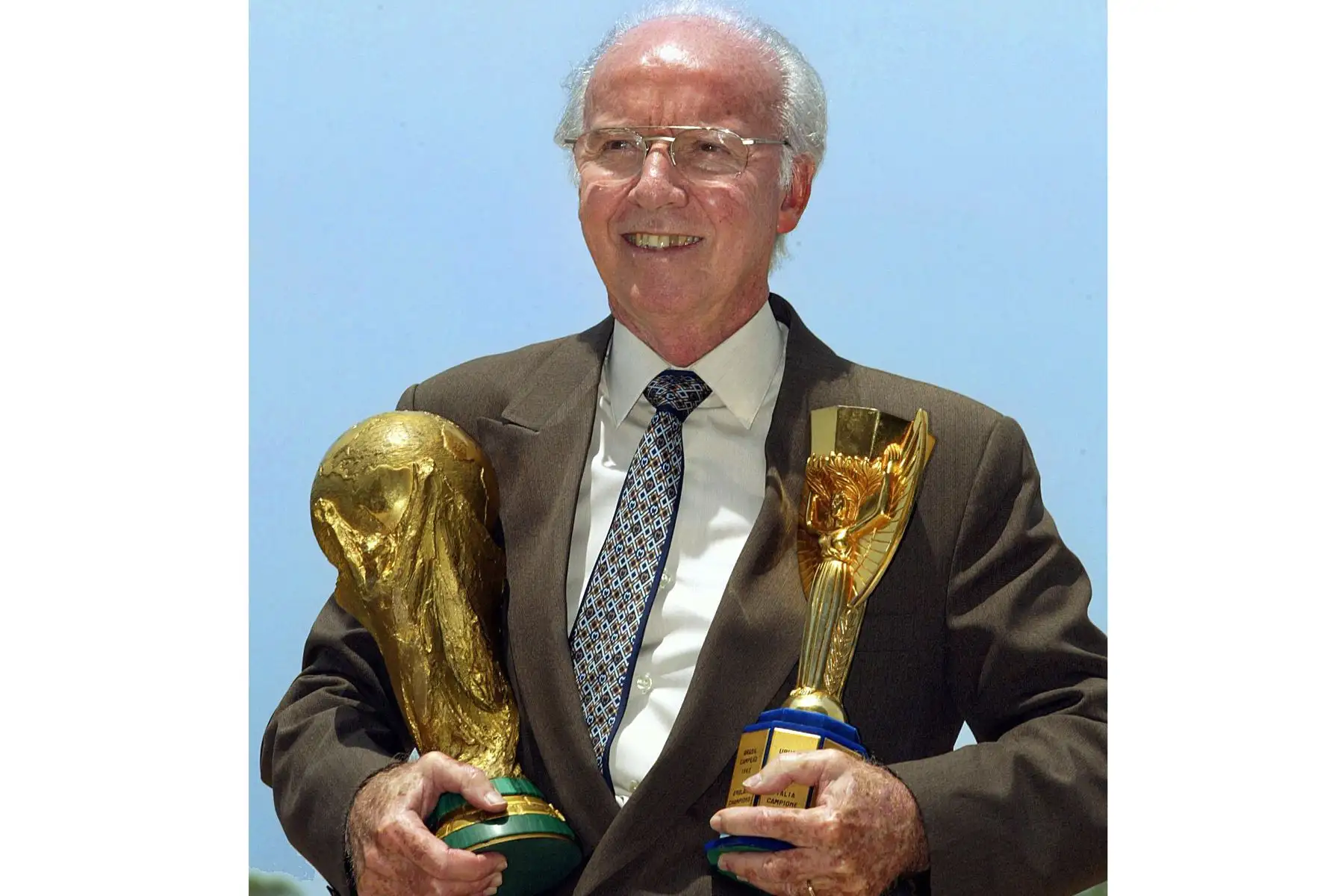 Mario Zagallo, cuatro veces ganador de la Copa Mundial, sostiene los trofeos Jules Rimet  y de la FIFA mientras posa para fotógrafos en Río de Janeiro, Brasil, en marzo de 2003. La leyenda del fútbol brasileño y cuatro veces campeón mundial Mario Zagallo murió el 5 de enero. de 2024 a la edad de 92 años, según un comunicado en su cuenta oficial de Instagram.
Foto: AFP