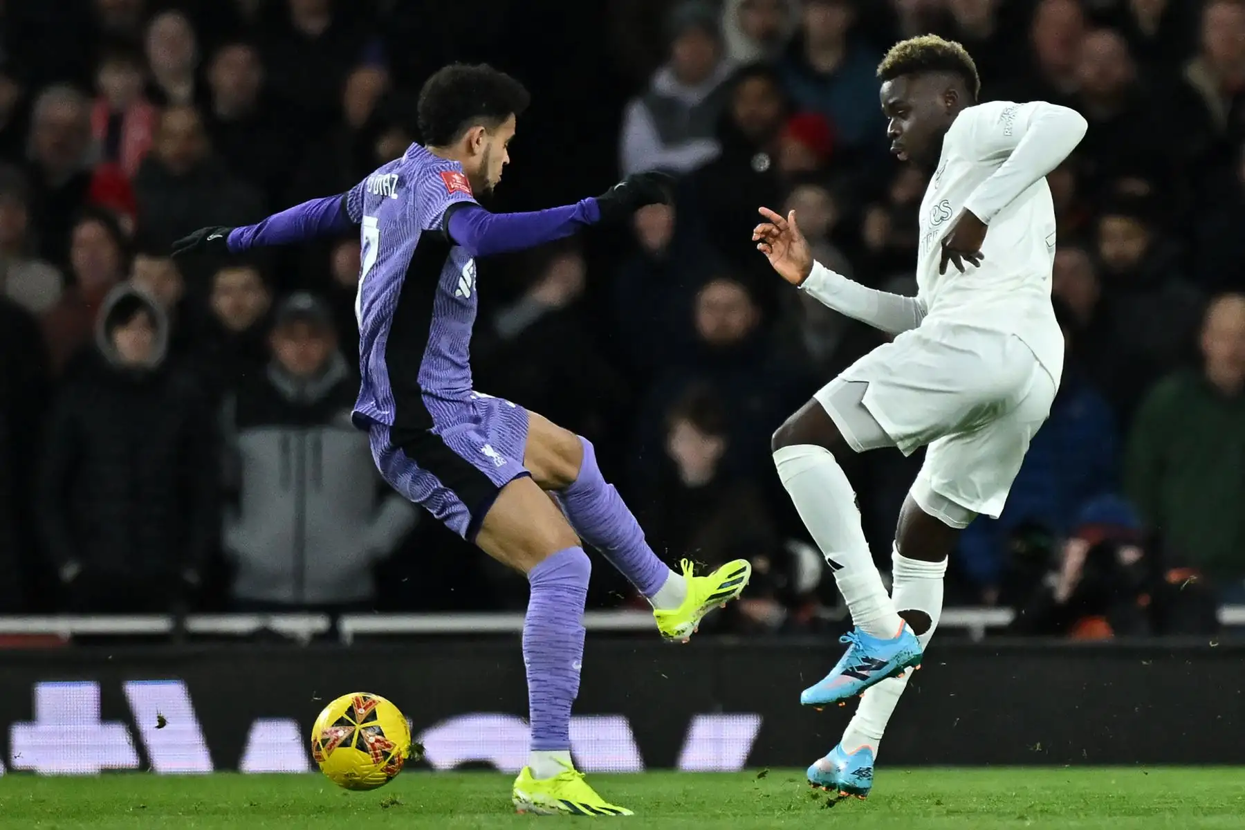 El centrocampista colombiano del Liverpool Luis Díaz compite con el centrocampista inglés del Arsenal Bukayo Saka durante el partido de fútbol de tercera ronda de la Copa FA inglesa entre Arsenal y Liverpool en el Emirates Stadium de Londres. Foto: ANDINA/ AFP