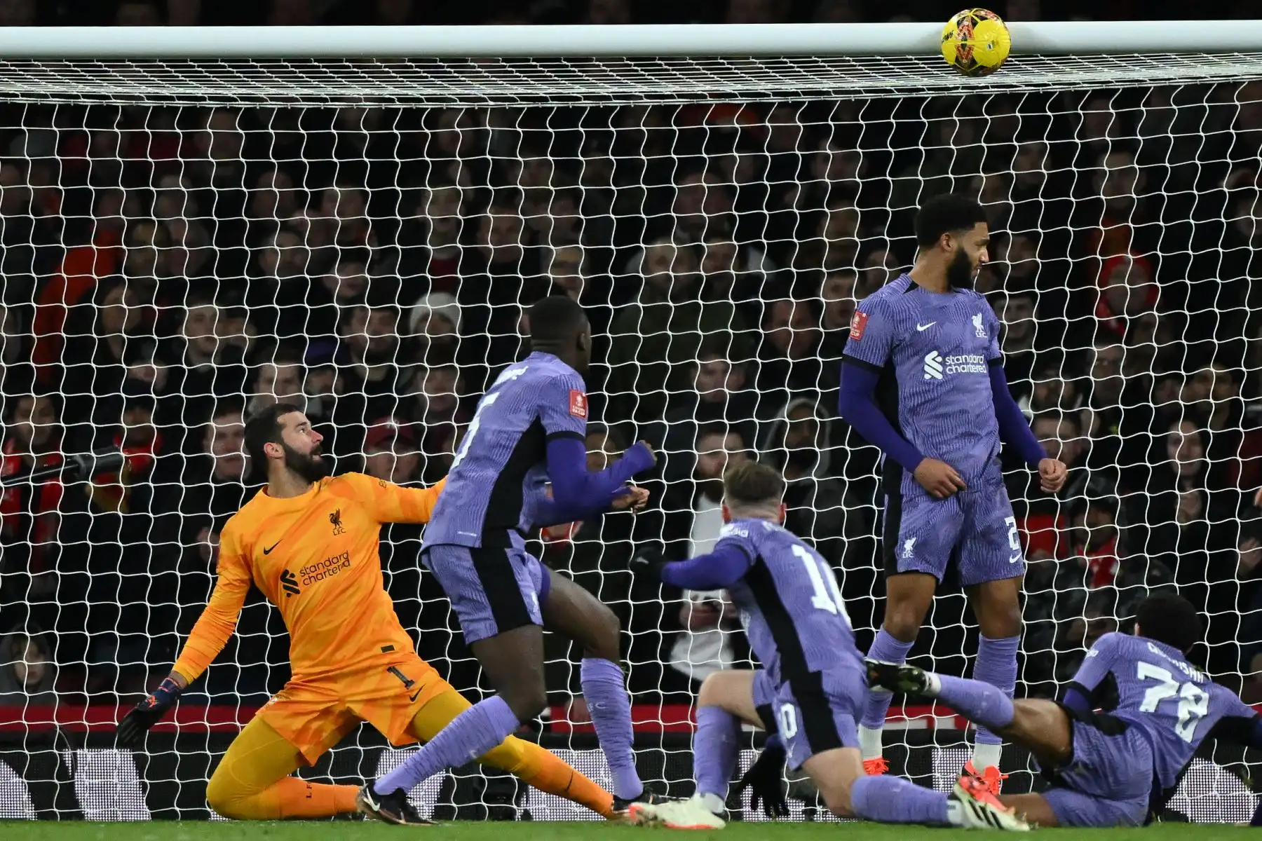 El portero brasileño del Liverpool Alisson Becker observa un disparo del mediocampista noruego del Arsenal Martin Odegaard regresar del travesaño durante el partido de fútbol de tercera ronda de la Copa FA inglesa entre Arsenal y Liverpool en el Emirates Stadium de Londres. Foto: AFP