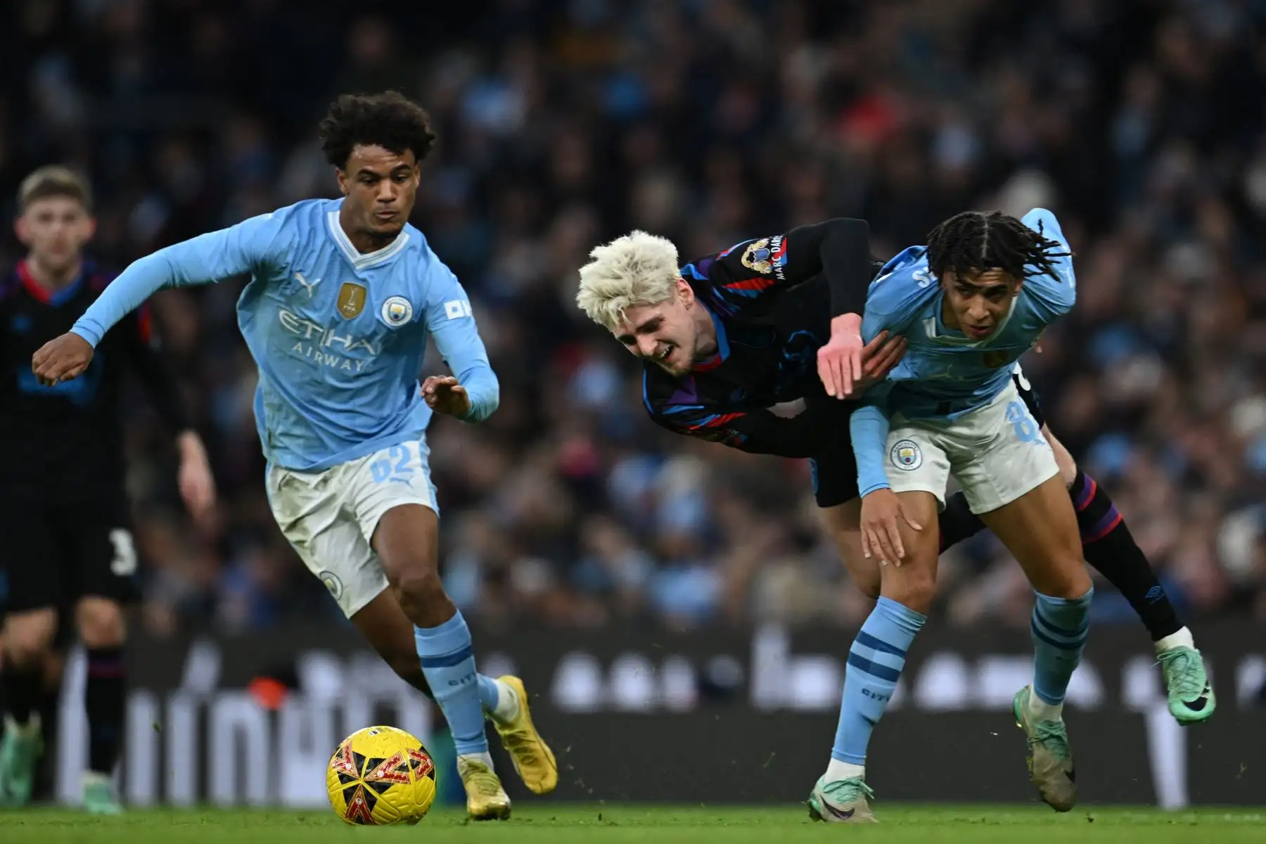 El centrocampista inglés de Huddersfield Town Jack Rudoni compite con el centrocampista noruego de Manchester City  Oscar Bobb y el defensor inglés de Manchester City Rico Lewis durante el partido de fútbol de la tercera ronda de la Copa FA inglesa entre Manchester City y Huddersfield Ciudad en el estadio Etihad de Manchester, noroeste de Inglaterra. Foto: ANDINA/AFP